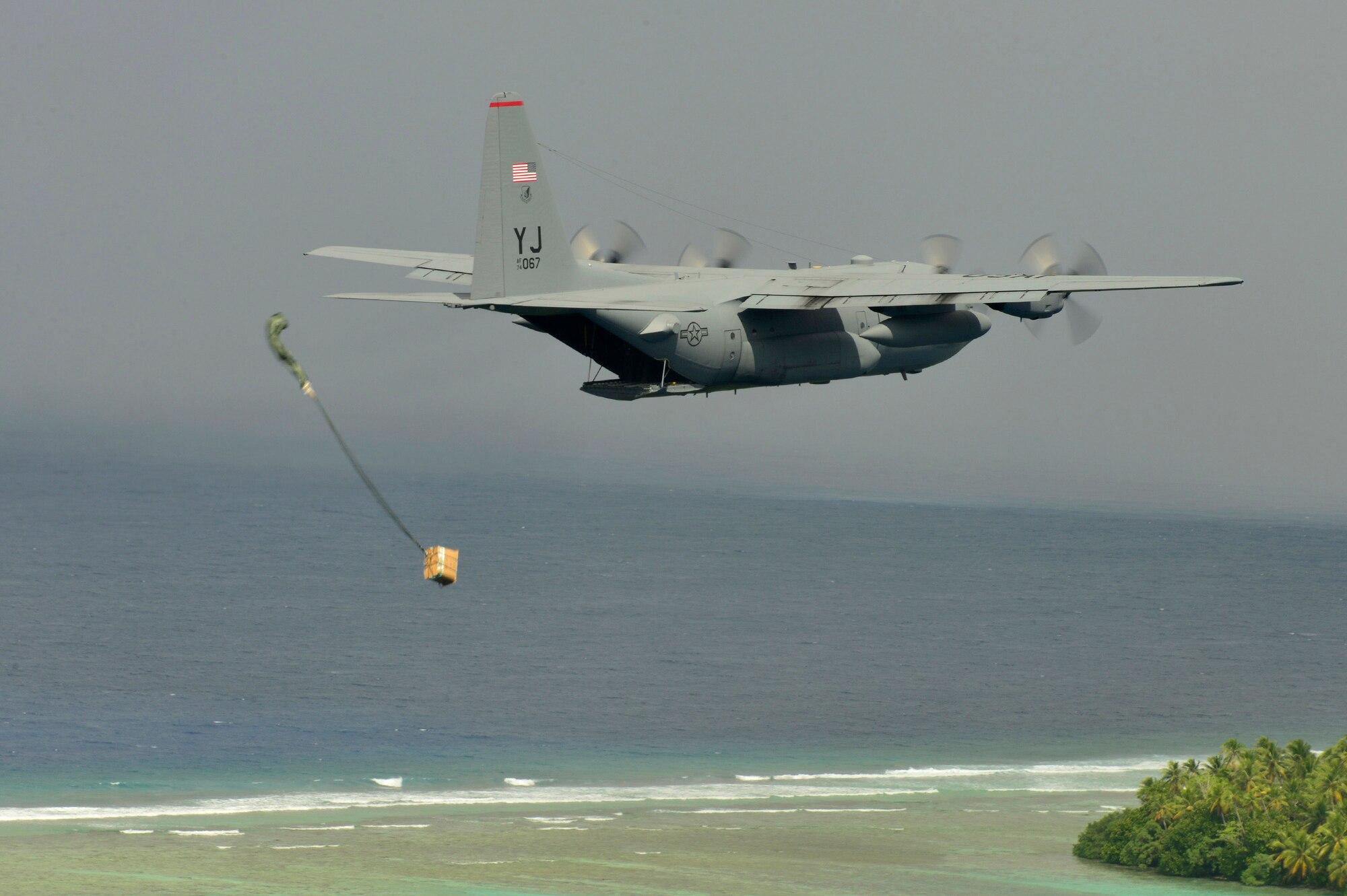A C-130 Hercules airdrops supplies to Micronesian islanders during Operation Christmas Drop near Andersen Air Force Base, Guam, Dec. 16, 2013. This year marks the 62nd year of Operation Christmas Drop, which began in 1952, making it the world's longest running airdrop mission. Every December, C-130 Hercules crews from the 374th Airlift Wing at Yokota Air Base, Japan, partner with the 36th Wing at Andersen Air Force Base, Guam, to airlift food, supplies and toys to islanders throughout Micronesia. (U.S. Air Force photo by 2nd Lt. Jake Bailey/Released)