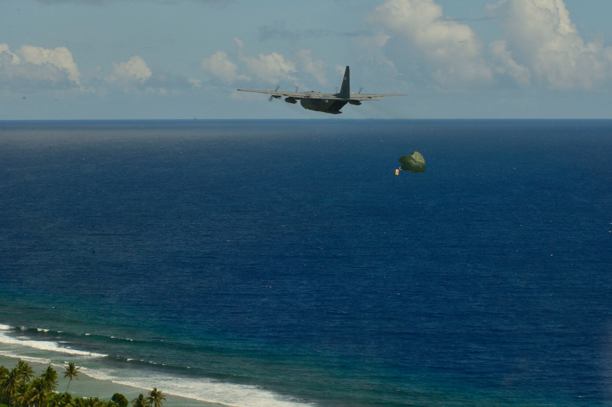 A C-130 Hercules airdrops supplies to Micronesian islanders during Operation Christmas Drop near Andersen Air Force Base, Guam, Dec. 16, 2013. This year marks the 62nd year of Operation Christmas Drop, which began in 1952, making it the world's longest running airdrop mission. Every December, C-130 Hercules crews from the 374th Airlift Wing at Yokota Air Base, Japan, partner with the 36th Wing at Andersen Air Force Base, Guam, to airlift food, supplies and toys to islanders throughout Micronesia. (U.S. Air Force photo by 2nd Lt. Jake Bailey/Released)