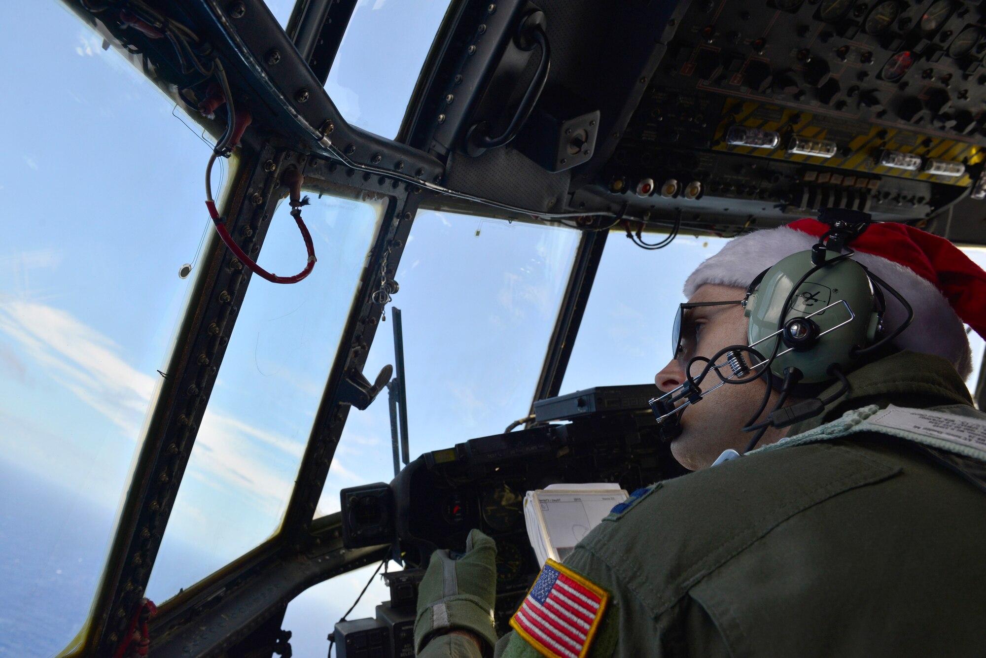 Capt. Matthew Smith, 36th Airlift Squadron pilot, flies an airdrop mission near Pakin, Federated States of Micronesia, during Operation Christmas Drop Dec. 15, 2013. This year marks the 62nd year of Operation Christmas Drop, which began in 1952, making it the world's longest running airdrop mission. Every December, C-130 Hercules crews from the 374th Airlift Wing at Yokota Air Base, Japan, partner with the 36th Wing at Andersen Air Force Base, Guam, to airlift food, supplies and toys to islanders throughout Micronesia. (U.S. Air Force photo by 2nd Lt. Jake Bailey/Released)