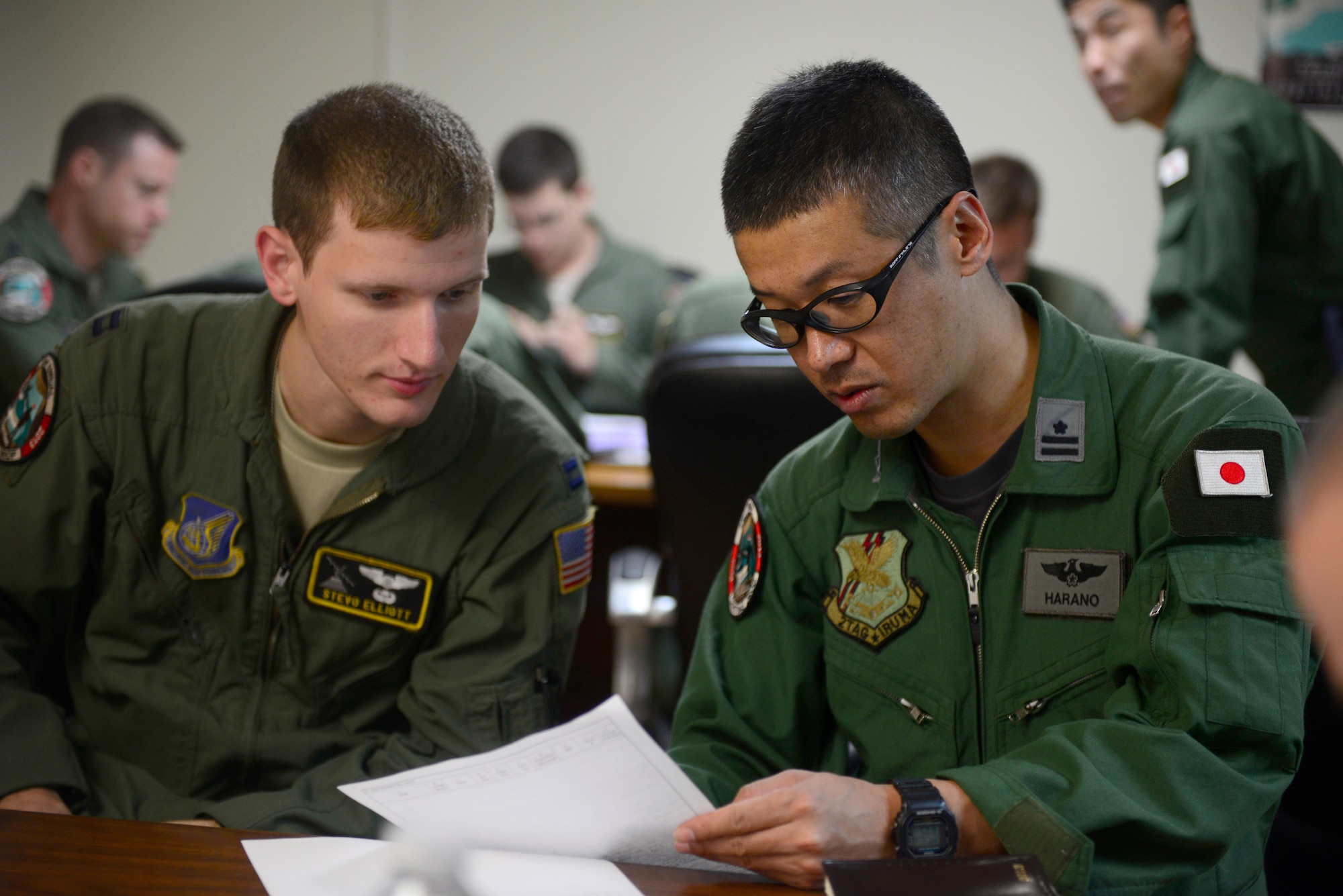 Capt. Stevo Elliot, 36th Airlift Squadron, Yokota Air Base, Japan, conducts mission planning with a member of the Japan Air Self-Defense Force before an airdrop mission during Operation Christmas Drop at Andersen Air Force Base, Guam, Dec. 16, 2013. This year marks the 62nd year of Operation Christmas Drop, which began in 1952, making it the world's longest running airdrop mission. Every December, C-130 Hercules crews from the 374th Airlift Wing at Yokota Air Base, Japan, partner with the 36th Wing at Andersen Air Force Base, Guam, to airlift food, supplies and toys to islanders throughout Micronesia. (U.S. Air Force photo by 2nd Lt. Jake Bailey/Released)