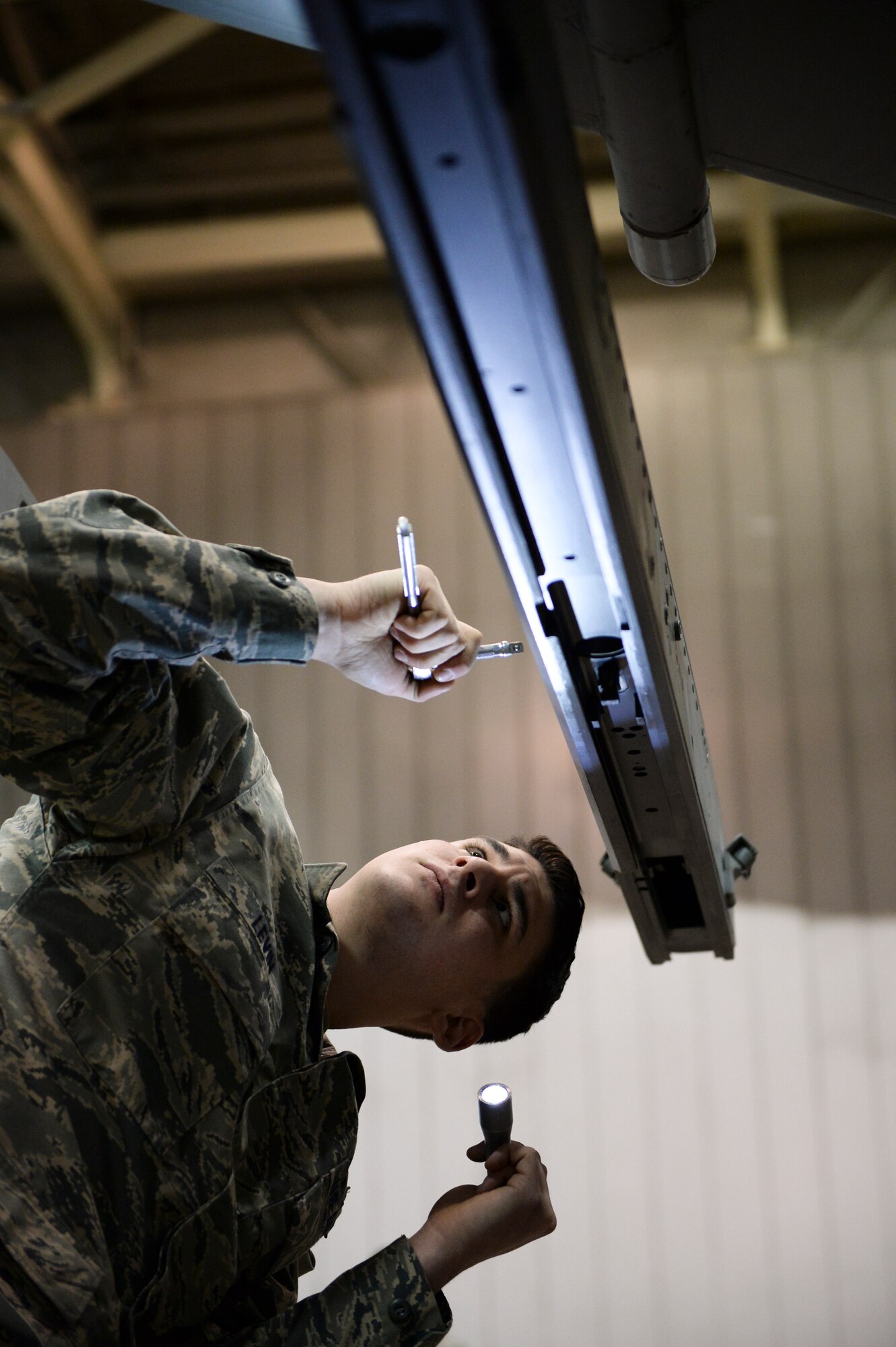 U.S. Air Force Senior Airman Joseph Levin, 354th Aircraft Maintenance Squadron weapons load crew member, inspects an F-16 Fighting Falcon launcher 129 in an aircraft maintenance hangar during an annual load crew competition Dec. 13, 2013, Eielson Air Force Base, Alaska. Levin readied the aircraft for a timed weapon loading event. (U.S. Air Force photo by Airman 1st Class Peter Reft/Released)