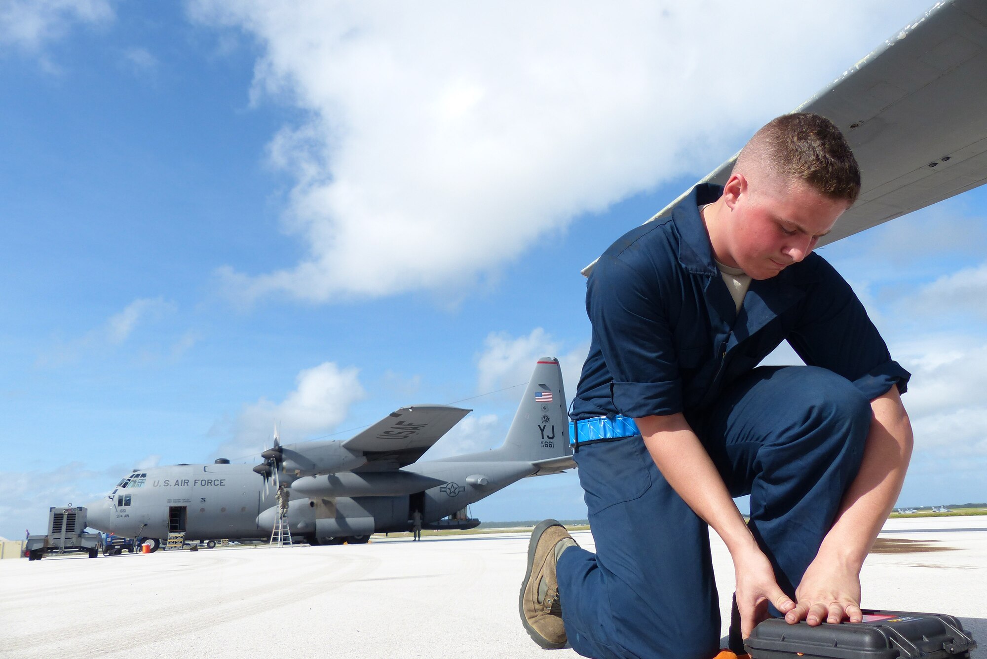 Airman 1st Class Nathan Judd, 374th Aircraft Maintenance Squadron crew chief, Yokota Air Base, Japan, opens a C-130H aircraft maintenance inspection kit before an airdrop mission during Operation Christmas Drop at Andersen Air Force Base, Guam, Dec. 14, 2013. This year marks the 62nd year of Operation Christmas Drop, which began in 1952, making it the world's longest running airdrop mission. Every December, C-130 Hercules crews from the 374th Airlift Wing at Yokota Air Base, Japan, partner with the 36th Wing at Andersen Air Force Base, Guam, to airlift food, supplies and toys to islanders throughout Micronesia. (U.S. Air Force photo by 2nd Lt. Jake Bailey/Released)
