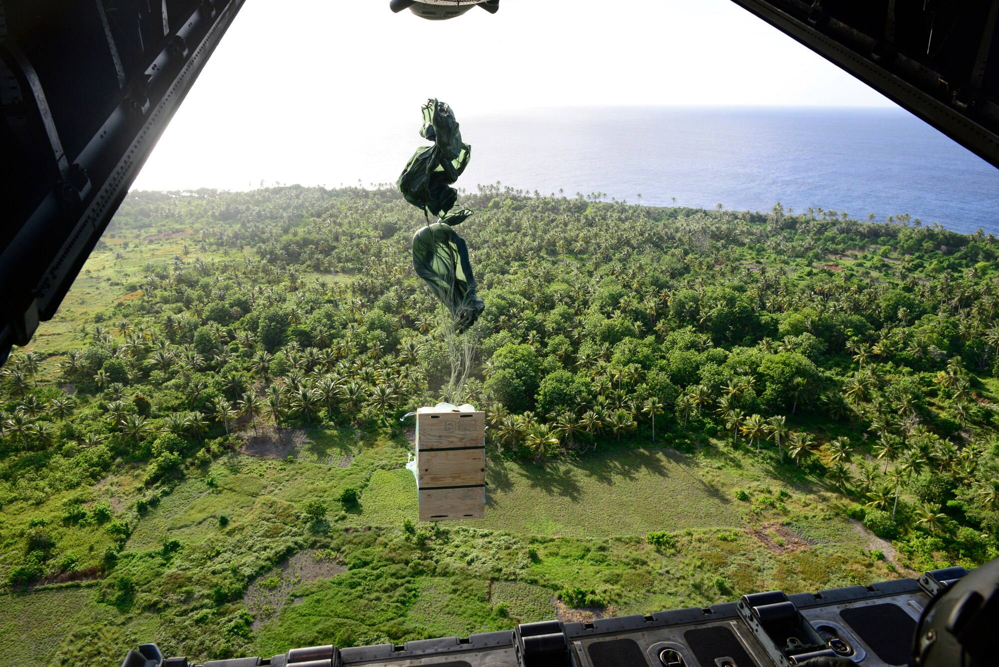 A low-cost, low-altitude bundle exits the ramp of a C-130H aircraft during an airdrop mission over the Federated States of Micronesia during Operation Christmas Drop, Dec. 13, 2013. This year marks the 62nd year of Operation Christmas Drop, which began in 1952, making it the world's longest running airdrop mission. Every December, C-130 Hercules crews from the 374th Airlift Wing at Yokota Air Base, Japan, partner with the 36th Wing at Andersen Air Force Base, Guam, to airlift food, supplies and toys to islanders throughout Micronesia. (U.S. Air Force photo by 2nd Lt. Jake Bailey/Released)