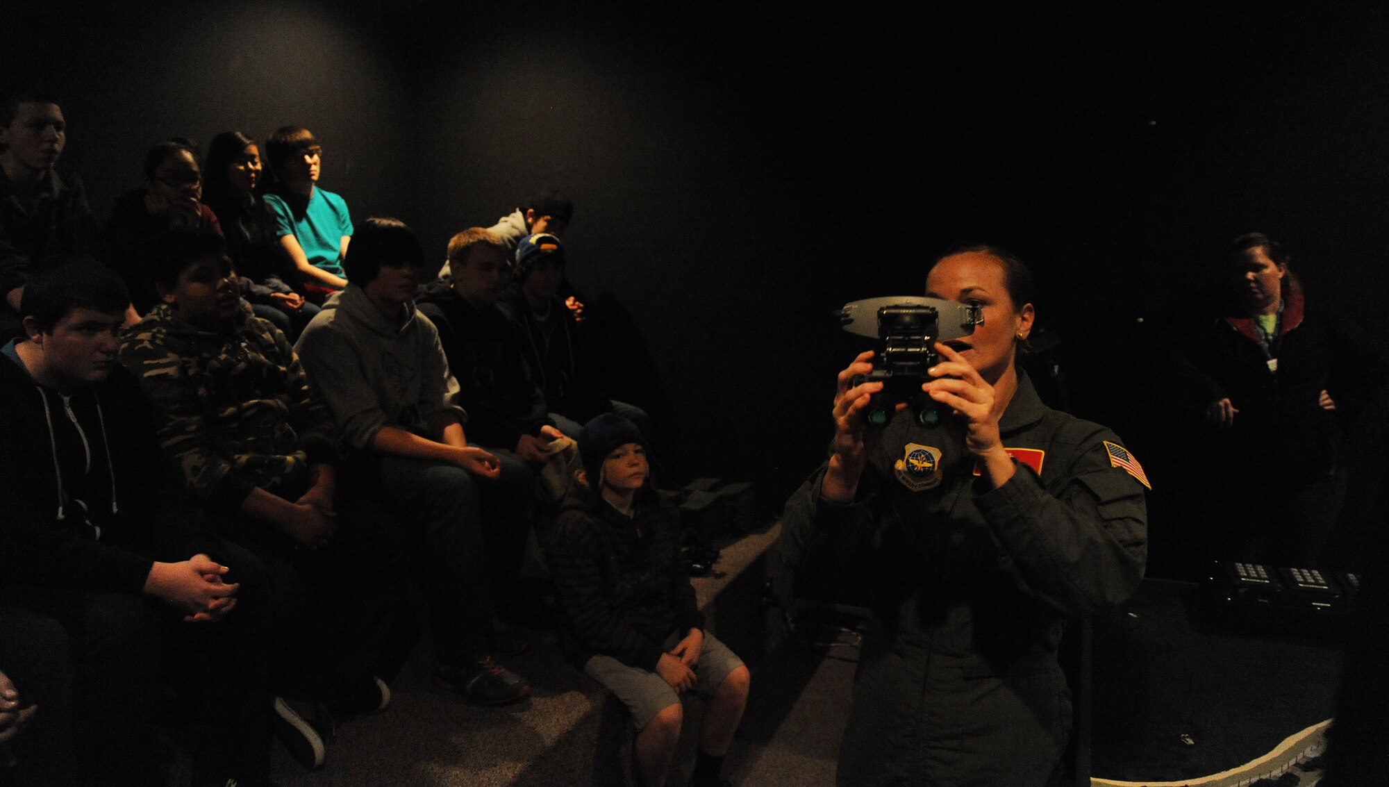 Staff Sgt. Bethany Whiteley, 92nd Aerospace Medicine Squadron aerospace and operational physiology craftsman, shows Garry Middle School students a pair of night-vision goggles at Fairchild Air Force Base, Wash., Dec. 17, 2013.  The goggles were used to demonstrate the various levels of illumination pilots encounter in the course of their work.  (U.S. Air Force photo by Airman 1st Class Sam Fogleman/Released)
