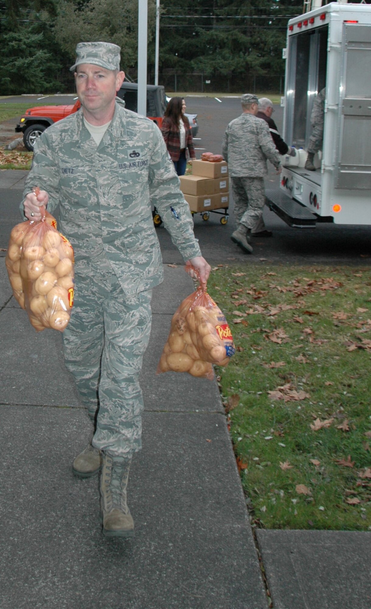 Chief Master Sgt. Chris Dietz, 86th Aerial Port Squadron, hauls in some potatoes for 32 holiday food baskets put together for 446th Airlift Wing Airmen in need.  Boxes of food were donated to the 446th AW by the Central Pierce County Fire Department. For the past eight years, these firefighters have supported families in need throughout Pierce County by giving them boxes full of food. (U.S. Air Force Reserve photo by Sandra Pishner)