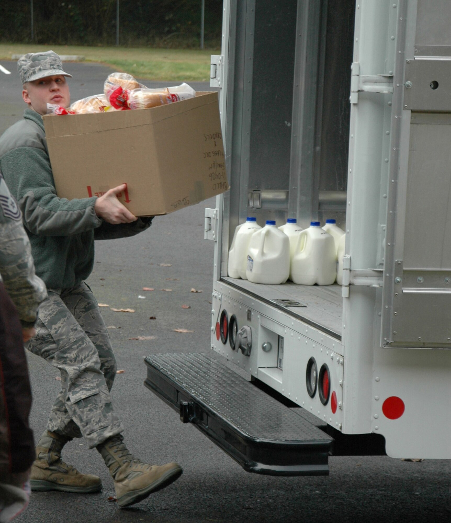 Senior Airman Michael Snyder, 446th Civil Engineer Squadron, grabs a box of bread for 32 holiday food baskets put together for 446th Airlift Wing Airmen in need.  Boxes of food were donated to the 446th AW by the Central Pierce County Fire Department. For the past eight years, these firefighters have supported families in need throughout Pierce County by giving them boxes full of food. (U.S. Air Force Reserve photo by Sandra Pishner)