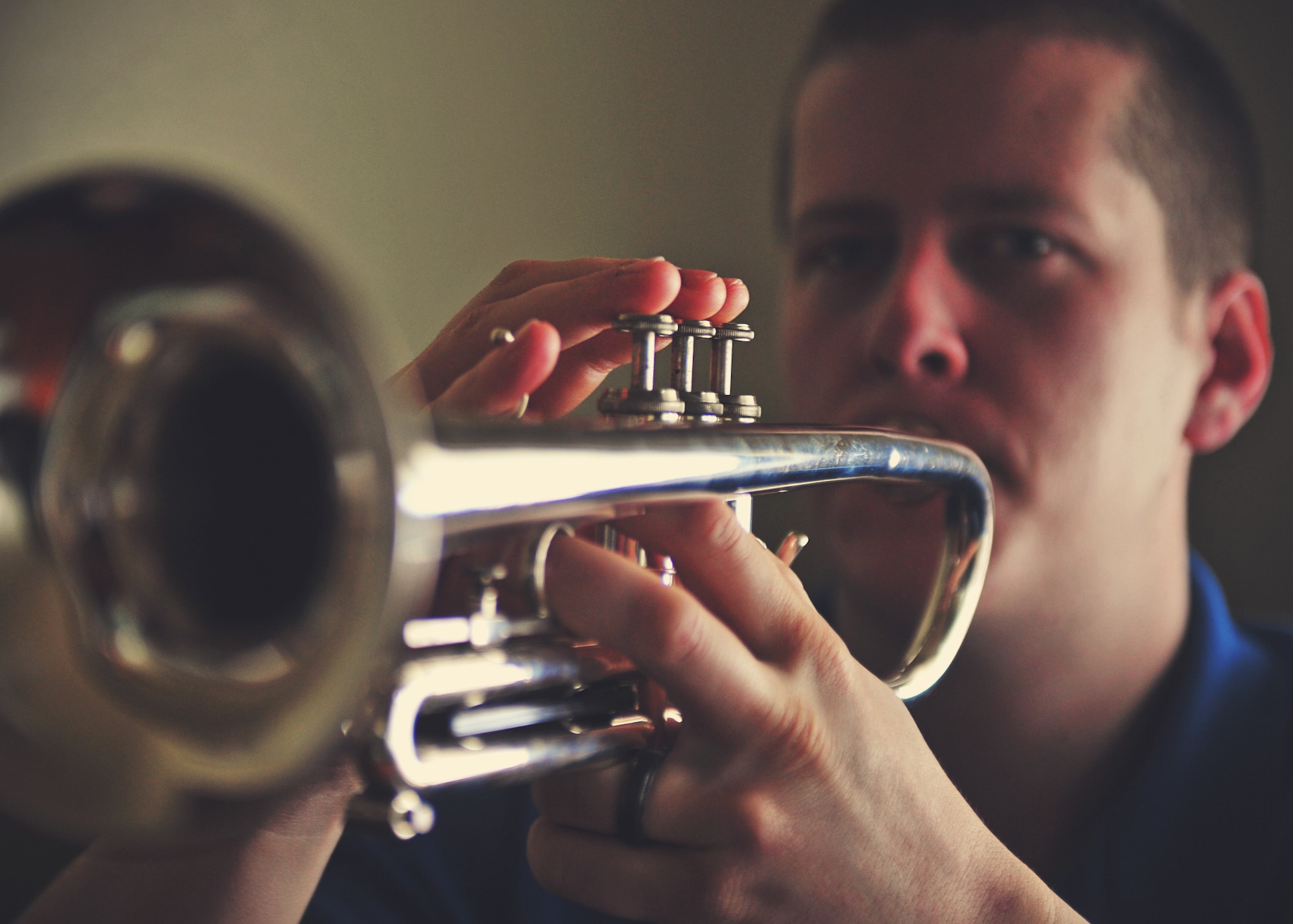 Senior Airman David Peterson, 92nd Aircraft Maintenance Squadron crew chief, plays his trumpet during a practice session at Fairchild Air Force Base, Wash., Dec. 16, 2013. Peterson often volunteers to stand in as a live bugler to play Taps during military honors at veteran funerals. (U.S. Air Force photo by Senior Airman Taylor Curry/Released) 