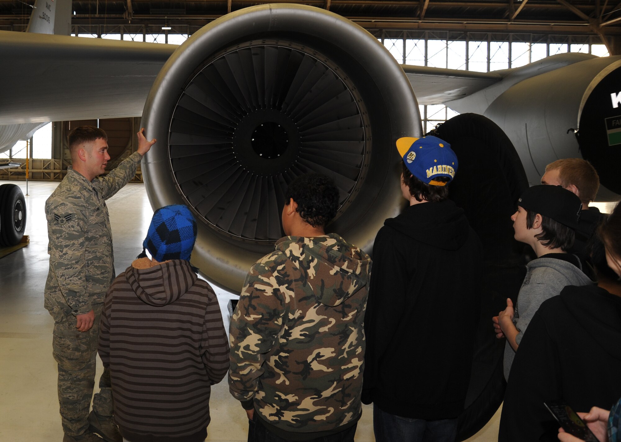 Senior Airman Nick Leland, 92nd Aircraft Maintenance Squadron assistant flying crew chief, shows Garry Middle School students one of the engines on a KC-135 Stratotanker at Fairchild Air Force Base, Wash., Dec. 17, 2013.  The students toured one of the aircraft in the hangar to better understand Fairchild's mission.  (U.S. Air Force photo by Airman 1st Class Sam Fogleman/Released)