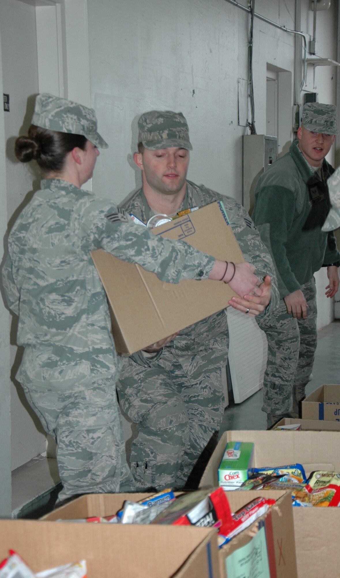 Senior Airman Rachel Bohannon, left, and Senior Airman Christopher Hussey, both with the 446th Civil Engineer Squadron, pick up boxes of food for holiday baskets Dec. 17.  Thirty-two boxes of food were donated to the 446th Airlift Wing by the Central Pierce County Fire Department. For the past eight years, these firefighters have supported families in need throughout Pierce County by giving them boxes full of food. (U.S. Air Force Reserve photo by Sandra Pishner)