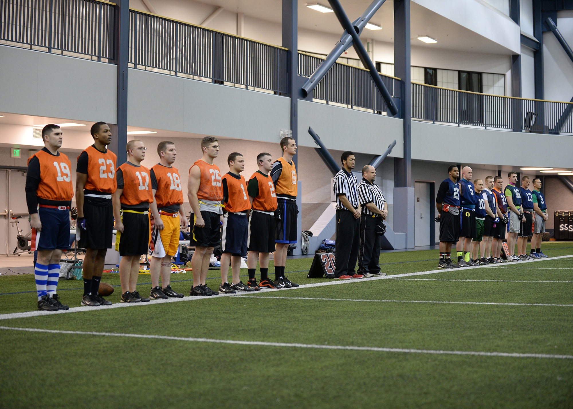 The 354th Maintenance Squadron and 168th Air Refueling Wing intramural football teams stand during the presentation of the colors during the championship games Dec. 16, 2013, Eielson Air Force Base, Alaska. The 168th ARW won both the games to become the champions for the second year in a row. (U.S. Air Force photo by Senior Airman Shawn Nickel/Released)