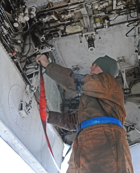 U.S. Air Force Airman 1st Class John Tevis, 7th Aircraft Maintenance Squadron B-1B Lancer crew chief, performs safety maintenance on the aircraft Dec. 12 2013, at Dyess Air Force Base, Texas. Tevis is wearing coveralls that are designed to protect from cold weather and to effectively block the wind. (U.S. Air Force photo by Airman 1st Class Kedesha Pennant/Released)