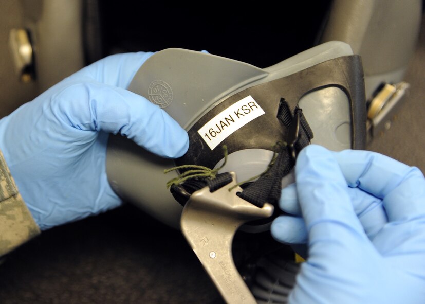Airman 1st Class Kristin Rush, 2nd Operational Support Squadron Aircrew Flight Equipment journeyman, places a tape label on a HGU-55P helmet on Barksdale Air Force Base, La., Dec. 17, 2013. The label is marked 30 days from the time of its last inspection, providing a reminder of when the next inspection is due. (U.S. Air Force photo/Senior Airman Joseph A. Pagán Jr.)