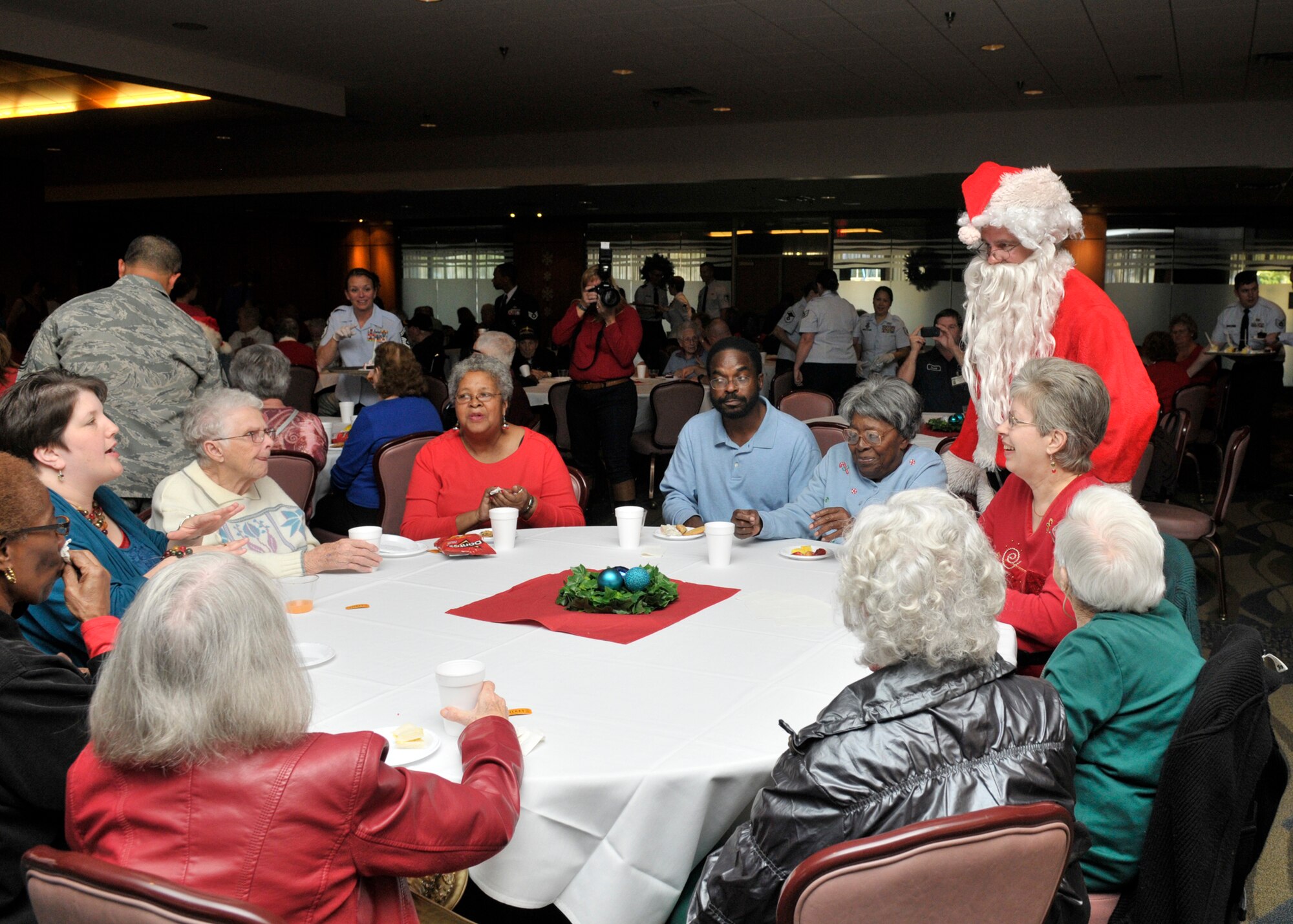 Santa visits with local senior citizens during the 27th Annual Golden Age holiday party for local senior citizens hosted by the Tyndall Chief’s Association Dec. 17 at Tyndall Air Force Base.  Airmen volunteers serve cake, cookies and help pass out gifts to attendees.  (U.S. Air Force photo by Staff Sgt. Javier Cruz)