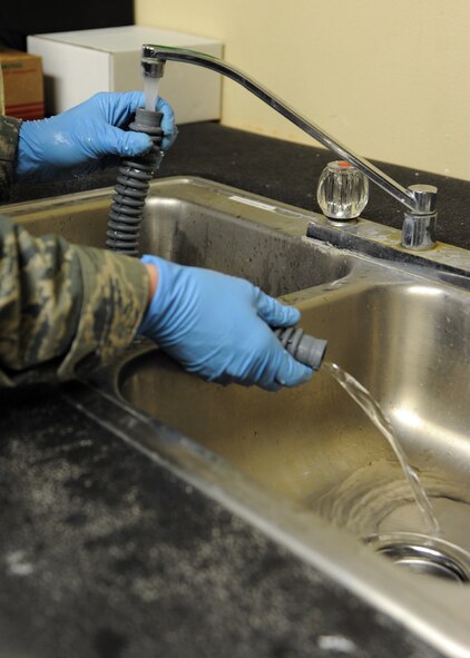 Airman 1st Class William Smith, 2nd Operational Support Squadron Aircrew Flight Equipment journeyman, washes a breathing hose with mild detergent and water on Barksdale Air Force Base, La., Dec. 17, 2013. The breathing hose needs to be sanitized every 30 days to prevent contaminates from building up and possibly causing harm to the pilot using it. (U.S. Air Force photo/Senior Airman Joseph A. Pagán Jr.)