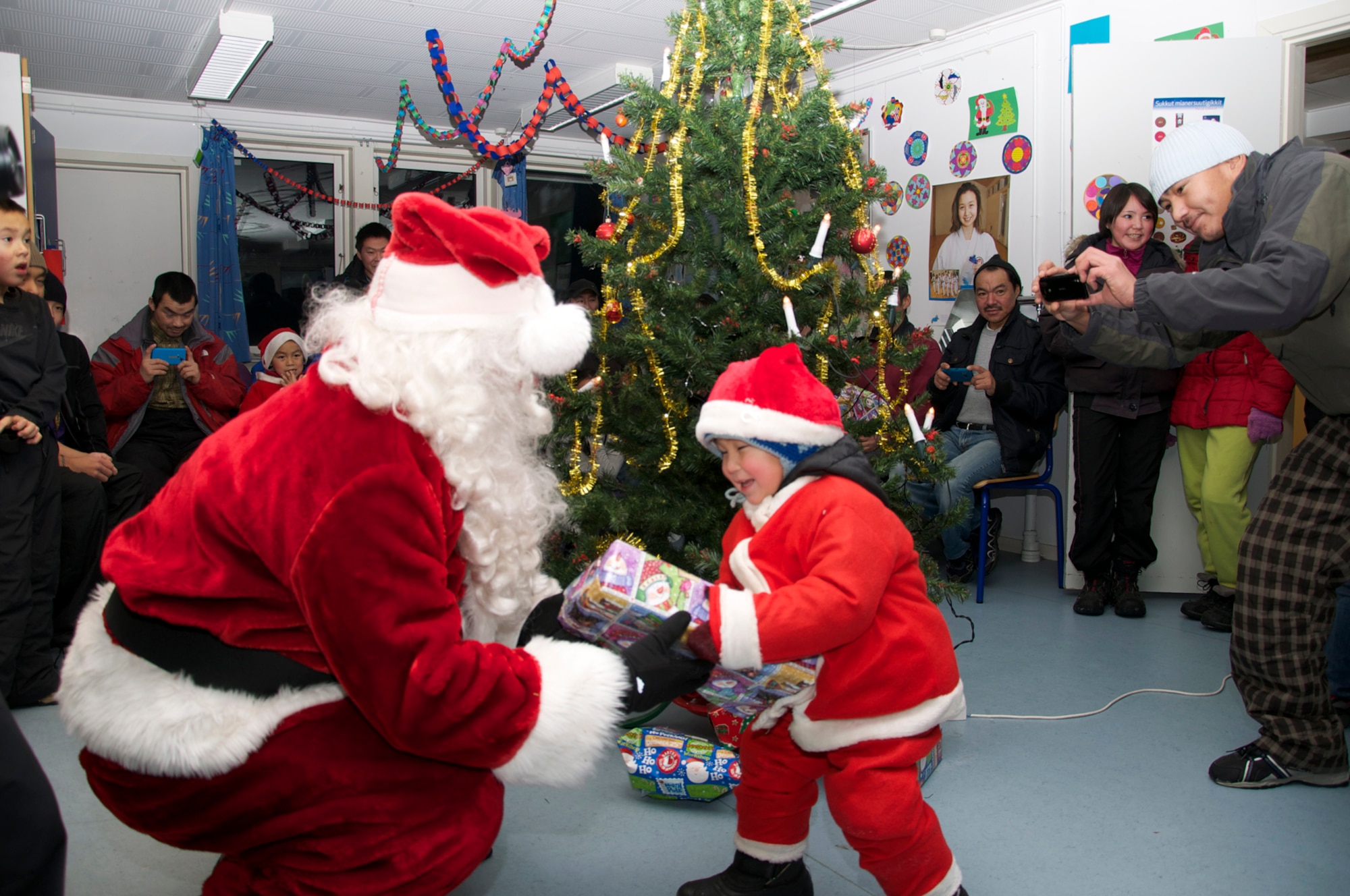 SAVISSIVIK, Greenland -- Julemand is greeted by a child at Savissivik, Greenland, during Thule Air Base’s Operation Julemand. The multi-national effort is held annually by U.S., Danish and Canadian military and civilian employees at Thule to promote goodwill with the Greenlandic people. Julemand is Danish for “Christmas Man” and is the equivalent to Santa Claus. (U.S. Air Force photo/Capt. Laura Simmons)
