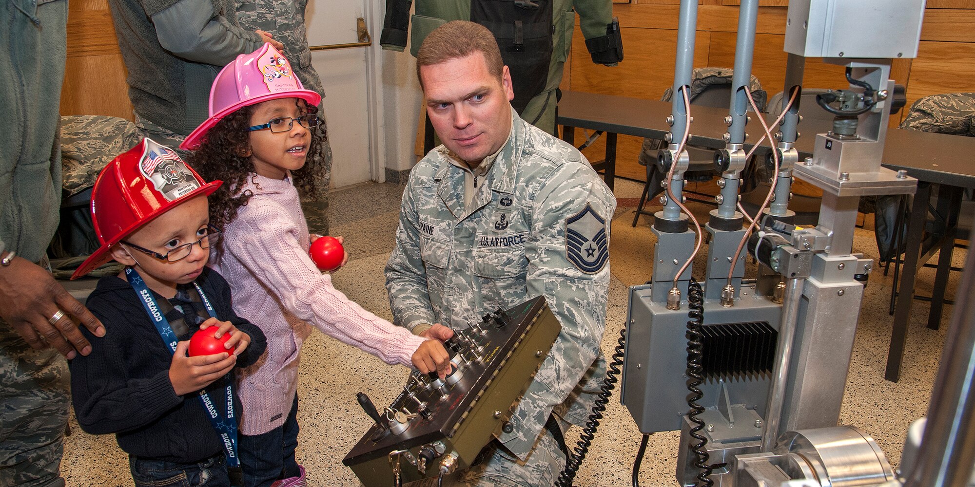 PETERSON AIR FORCE BASE, Colo. – Master Sgt. Jeremy Raine, 21st Civil Engineer Squadron Explosive Ordnance Disposal flight, demonstrates the flight’s robot to kids attending the tree lighting Dec. 6 at the chapel. The event featured photos with Santa, holiday music, refreshments, first responder display booths and a booth to make holiday cards to send to deployed troops. (U.S. Air Force photo/Craig Denton)