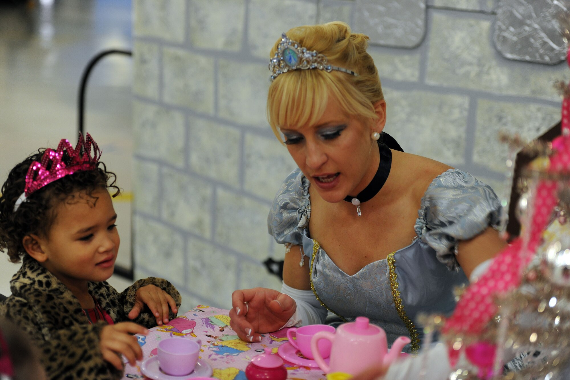 Cinderella sits down for a tea party with a PCFC family member Dec. 14, 2013 at the 26th Annual Parents and Children Fighting Cancer Christmas Party in Hangar 3 on Joint Base Andrews, Md. This event allow PCFC families to spend the day in a winter wonderland offering food, entertainment, gifts, static displays, and a visit from Santa and Mrs. Claus. (U.S. Air Force photo/Aimee Fujikawa)