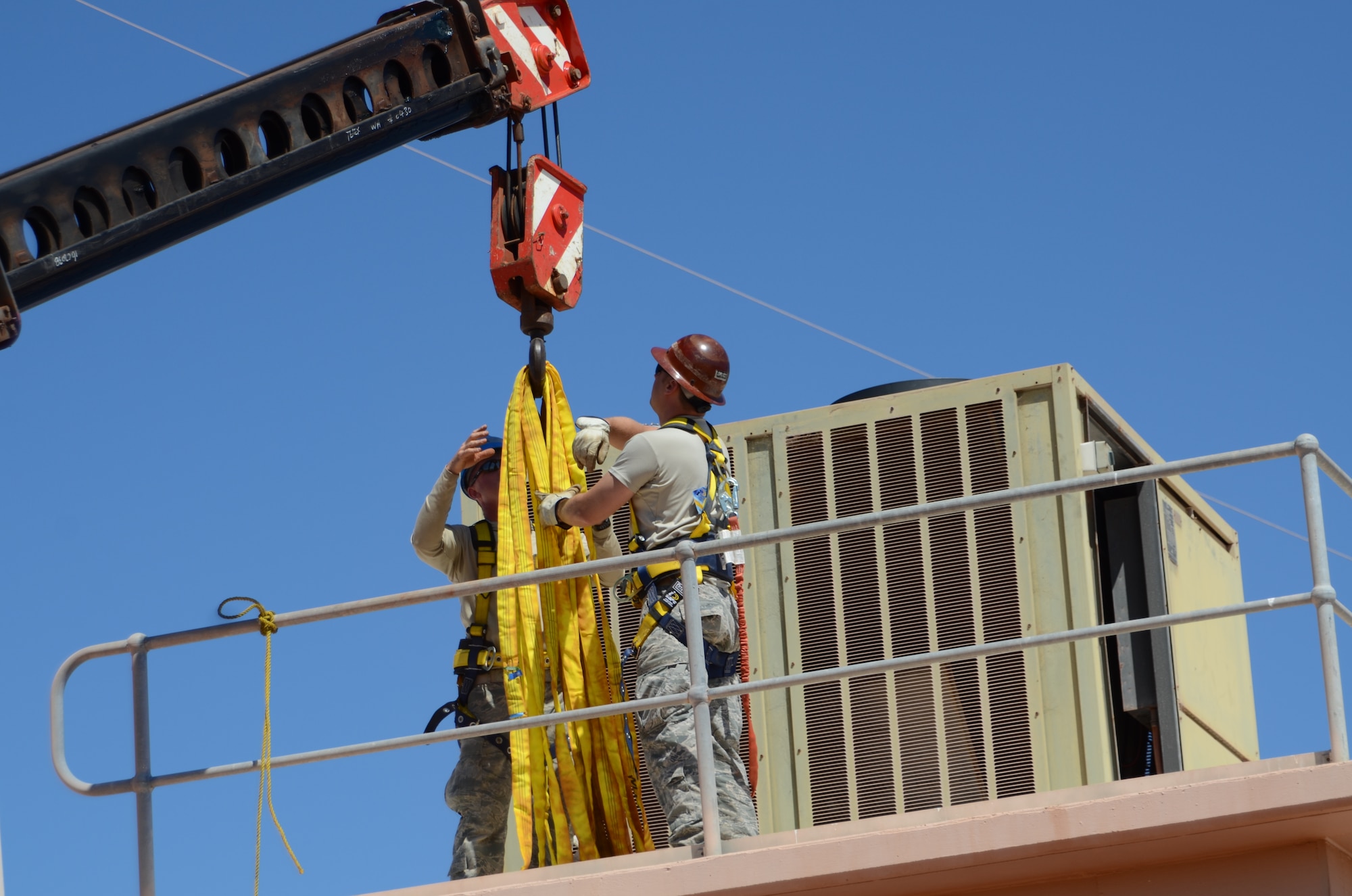 Master Sgt. Jeffery Dornin, a native of Keysport Ill., and Master Sgt. Randy Frantz, a native of Troy Ill., both members of the 126th Civil Engineer Squadron, attached to the 126th Air Refueling Wing, Illinois Air National Guard, prepare to hook up an old air conditioner to a crane to remove it from the roof of a building at Holt Naval Communication Station, Western Australia, Sep. 5, 2013. The air conditioner was removed as part of Operation C-Band Radar Pedestal And Structural NE NCS Holt-Western Australia where multiple Air National Guard units were completing a joint mission. (Air National Guard photo by Airman 1st Class Elise Stout) 