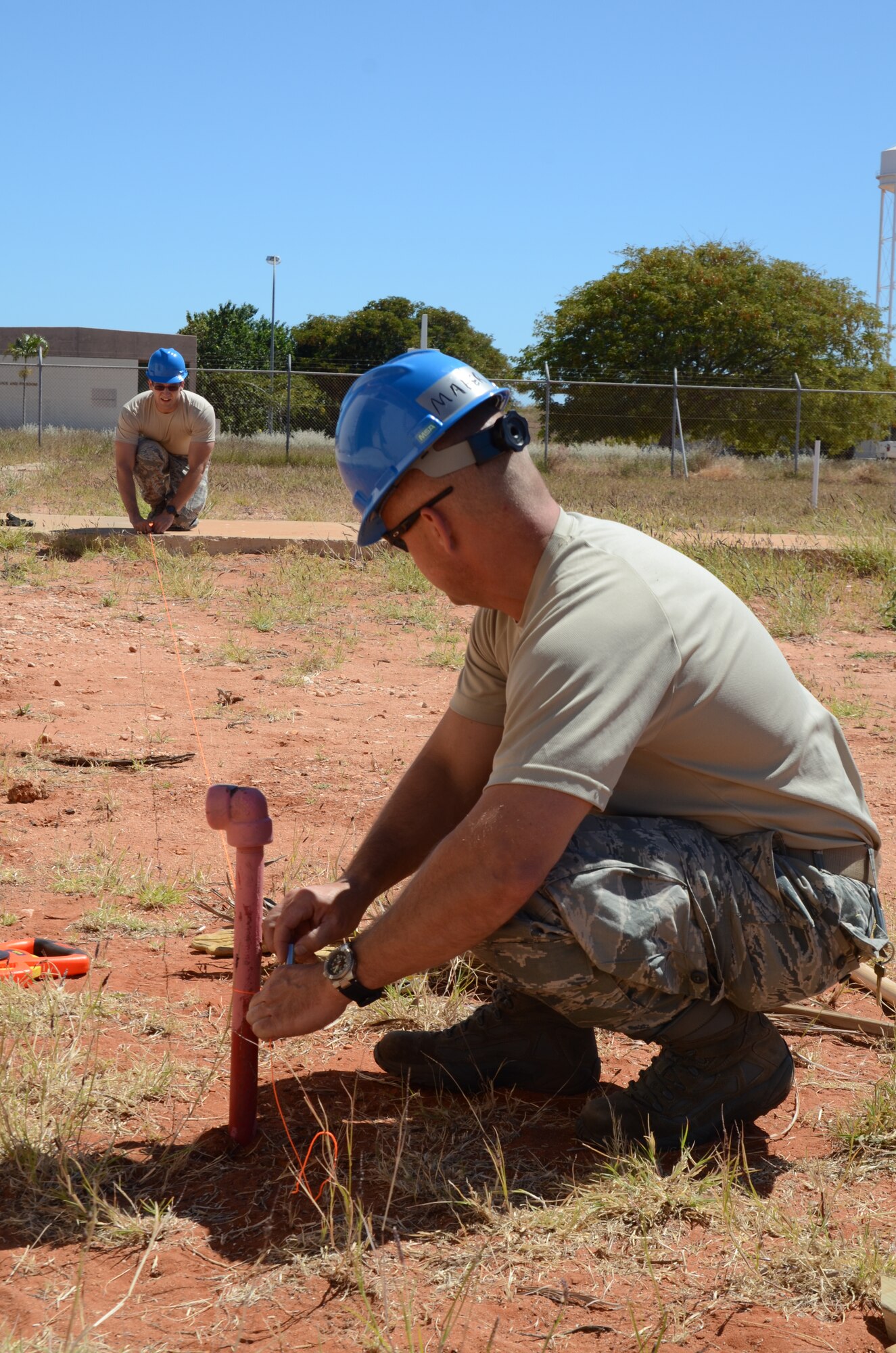 Tech. Sgt. Mike Maier, a native of Troy Ill., looks at Tech. Sgt. Joe Brakeville, a native and Alton Ill., while they make sure the surveying line is straight and level at Holt Naval Base Western Australia, Aug. 26, 2013. The 126th Civil Engineer Squadron members, attached to the 126th Air Refueling Wing, Illinois Air National Guard, performed surveying while installing a new facility for Operation C-Band Radar Pedestal And Structural NCS NE Holt- Western Australia that is being completed by multiple Air National Guard units. (Air National Guard photo by Airman 1st Class Elise Stout)
