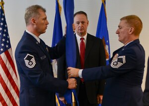 U.S. Air Force Master Sgt. William Fowler, left, Air Force Command and Control Integration Center knowledge operations superintendent and Senior Master Sgt. Lee Slaughter, AFC2IC fielded tactical data links superintendent, fold the AFC2IC unit guidon as Stan Newberry, AFC2IC director, looks on during AFC2IC’s closing ceremony, Hampton, Va., Dec. 16, 2013. The AFC2IC was created in 1997 to optimize command and control as an integral part of airpower and to achieve success through decision superiority. (U.S. Air Force photo by Senior Airman Connor Estes/Released)