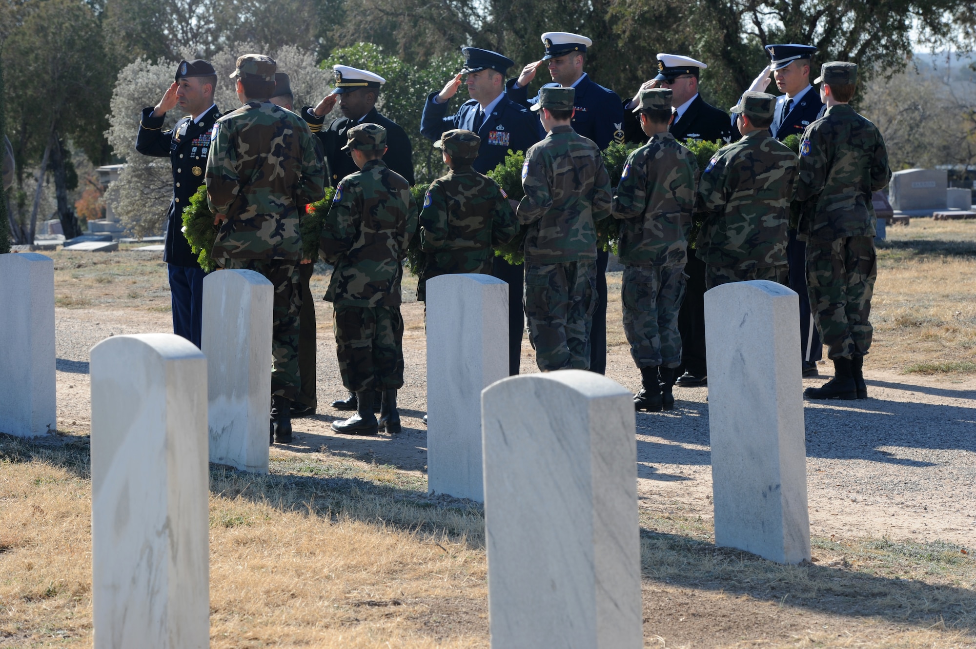 SAN ANGELO, Texas – Members of Goodfellow Air Force Base render a salute during the playing of the national anthem as members of the San Angelo Composite Squadron Civil Air Patrol hold wreaths that Goodfellow members will place at the flagpole during the Wreaths Across America ceremony at the Belvedere Cemetery Dec. 14. Locally hosted by the San Angelo Composite Squadron Civil Air Patrol, Wreaths Across America’s mission is to Remember, Honor, Teach. (U.S. Air Force photo/ Staff Sgt. Laura R. McFarlane)