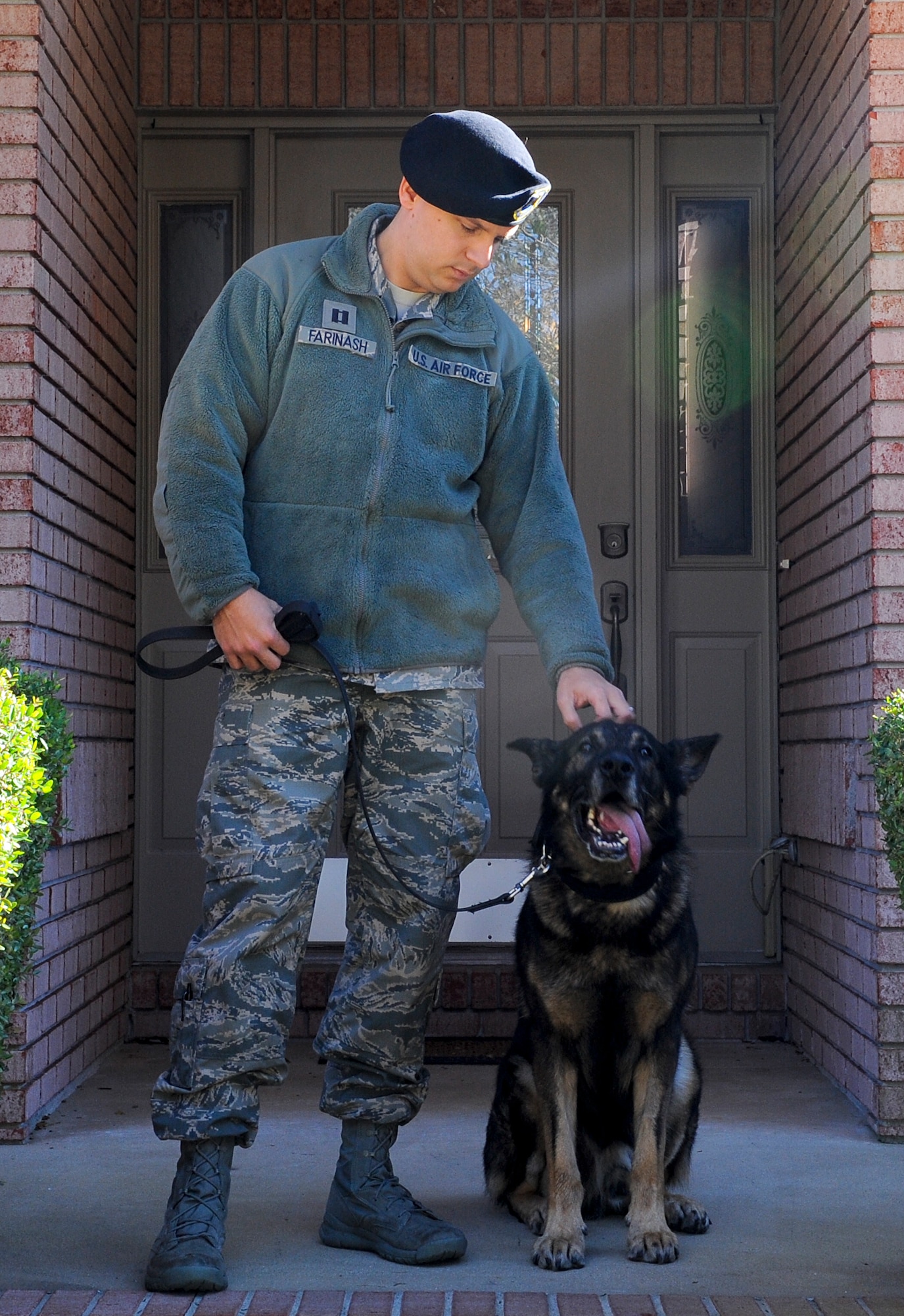 Capt. Joesph Farinash, 1st Special Operations Security Forces Squadron operations officer, stands with retired military working dog Luck, outside his home in Navarre, Fla., Dec. 17, 2013. Luck served more than 7 years in the Air Force. (U.S. Air Force photo/Airman 1st Class Jeff Parkinson)
