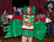 Staff Sgt. Josh Taylor, 90th Missile Wing Protocol, shows off the sweater he wore to the 90th Missile Wing holiday party Dec. 15, 2013. Taylor won the “Ugly Sweater Contest,” a contest pitting the most aesthetically unappealing holiday-themed sweaters against one another to see which one can put off the most people. Taylor’s vaguely Elvis-like sweater clinched the win. (U.S. Air Force photo by Airman 1st Class Jason Wiese)