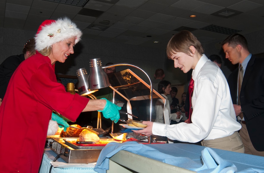 Valeriana O’Brien, Trail’s End Club cook, serves Airman 1st Class Julia Bullock, 90th Communications Squadron client systems technician, at the 90th Missile Wing holiday party in the Trail’s End Club Dec. 15, 2013. The Trail’s End Club hosts functions for both organizations on base and for individual Airmen and families. (U.S. Air Force photo by Airman 1st Class Jason Wiese)