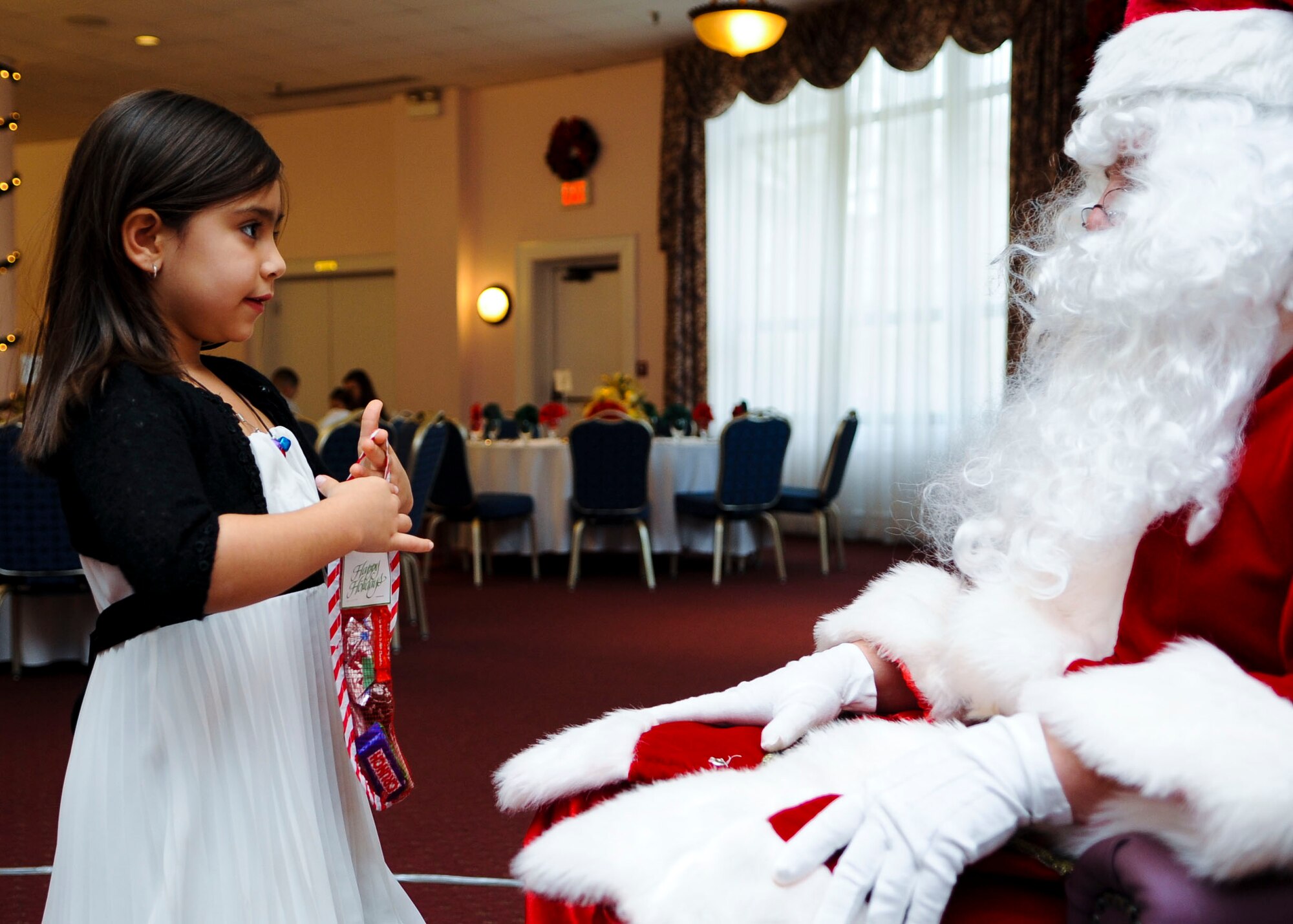 Jocelyn Day, granddaughter of Shelley Edwards, McDonald Army Health Center medical coder, tells “Santa Claus” what she wants for Christmas during the Breakfast with Santa event at Fort Eustis, Va., Dec. 14, 2013. Each child received a small stocking of candy, and caretakers took home complimentary photos. (U.S. Air Force photo by Airman 1st Class Austin Harvill/Released)