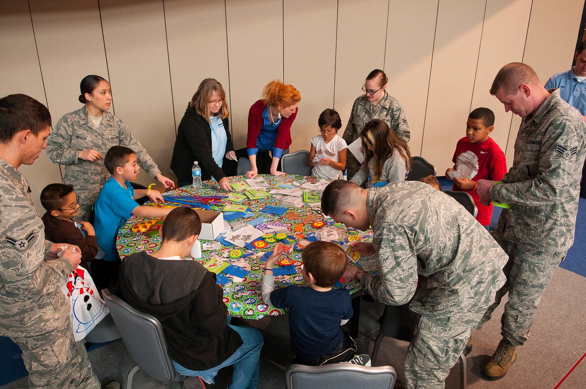 Airmen and children gather around a crafts table at Operation Provide Joy in the Fall Hall Community Center on F.E. Warren Air Force Base, Wyo., Dec. 14, 2013. The annual event pairs up local children and volunteer 90th Missile Wing Airmen to give the kids an opportunity to play games, eat pizza and get presents from Santa. (U.S. Air Force photo by R.J. Oriez)