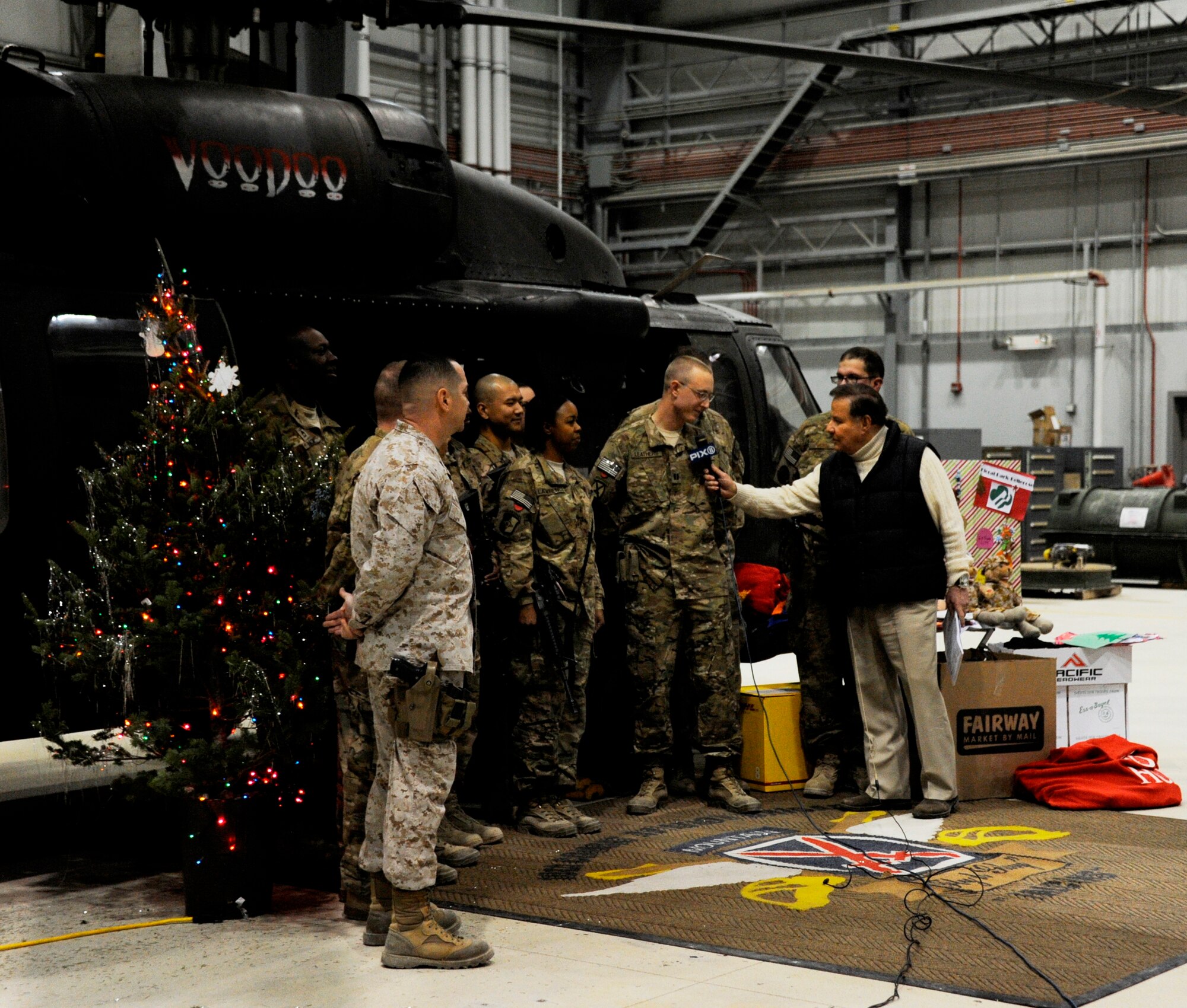 Marvin Scott, senior correspondent at Pix 11 in New York City, interviews service members during a live broadcast from Bagram Airfield, Afghanistan, Dec. 17, 2013. Scott, along with David Kimmel, a photojournalist at Pix 11, were embedded with the 455th Air Expeditionary Wing to spread holiday cheer to New York service members who are deployed during the holiday season. The two-man team traveled from Joint Base Andrews, Washington, D.C., aboard a C-17 Globemaster III assigned to the Mississippi Air National Guard. The team interviewed the C-17 aircrew and broadcast a video Dec. 16, 2013, on Pix 11 about how the unit contributes to the air mobility mission. (U.S. Air Force photo/1st Lt. Alexis McGee)