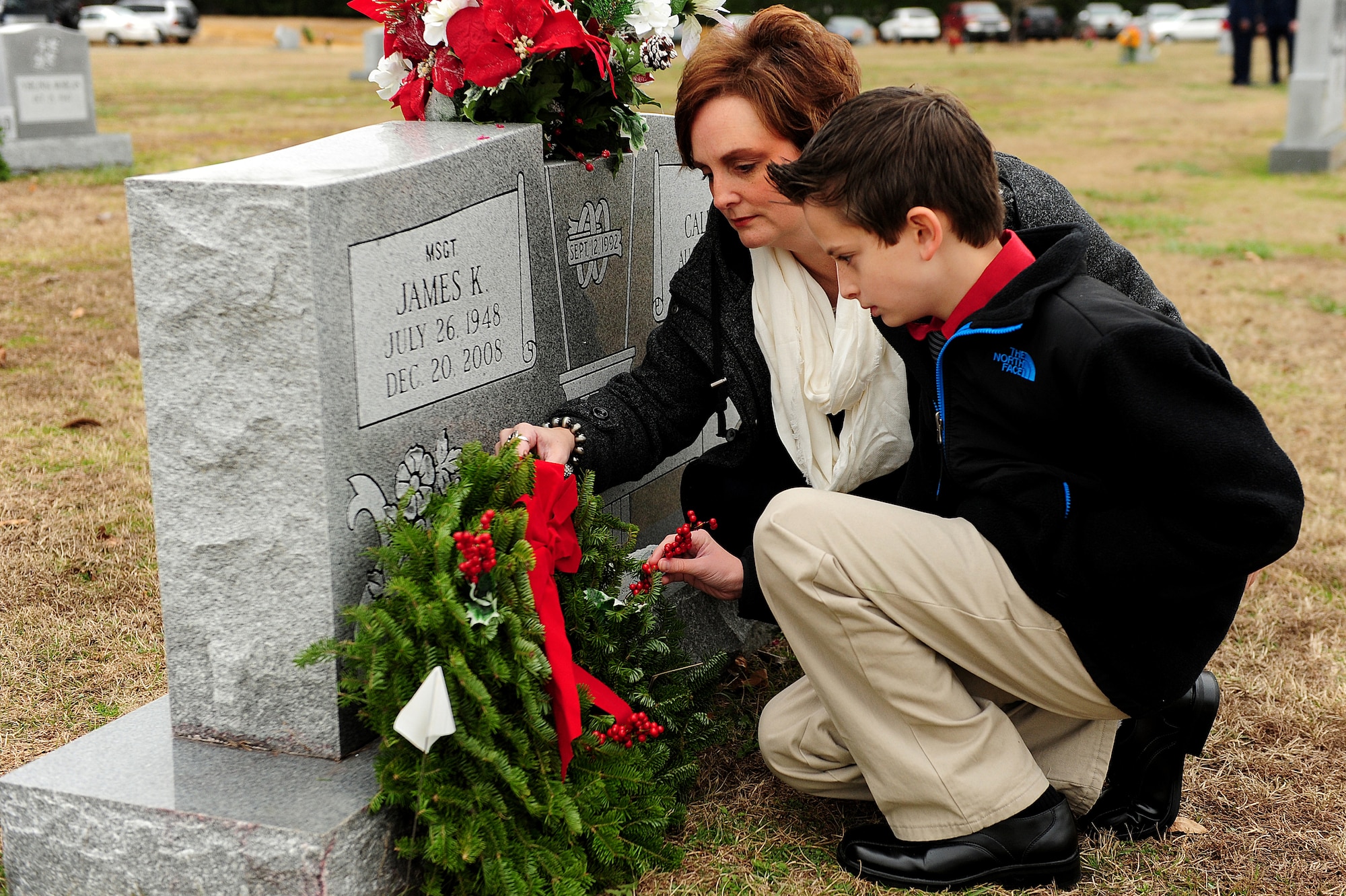 Kim Fortson and her son lay a wreath on her father’s grave during a wreath-laying ceremony at Evergreen Memorial Cemetery, Goldsboro, N.C., Dec. 14, 2013.  Retired Master Sgt. James Fortson served and retired from Seymour Johnson Air Force Base after more than 20 years.  The event was part of the Wreaths Across America mission, which delivered more than 540,000 remembrance wreaths to 908 cemeteries across the country in honor of our nation’s veterans.  (U.S. Air Force photo by Airman 1st Class Brittain Crolley)