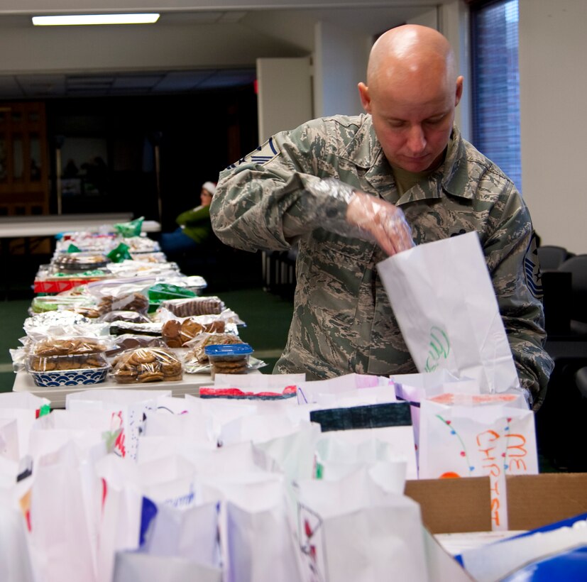 Master Sgt. Tim Allison, 19th Special Operations Squadron first sergeant, unfolds bags during the Commando Cookie Drop at the chapel on Hurlburt Field, Fla., Dec. 16, 2013. First sergeants will deliver bags of cookies to Airmen living in the dorms. (U.S. Air Force photo/Senior Airman Michelle Vickers) 