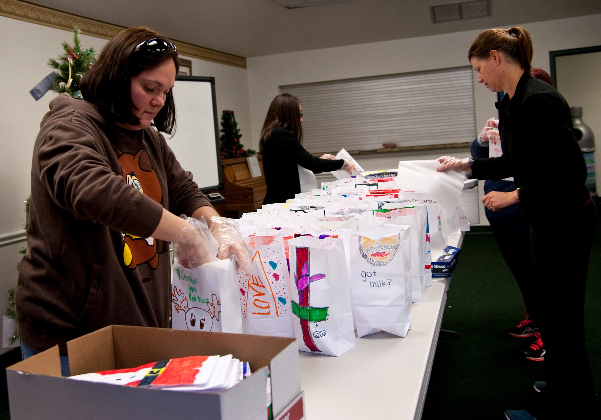 Volunteers assemble bags during the Commando Cookie Drop at the chapel on Hurlburt Field, Fla., Dec. 16, 2013. Local school children decorated the paper bags to hold holiday cookies. (U.S. Air Force photo/Senior Airman Michelle Vickers) 