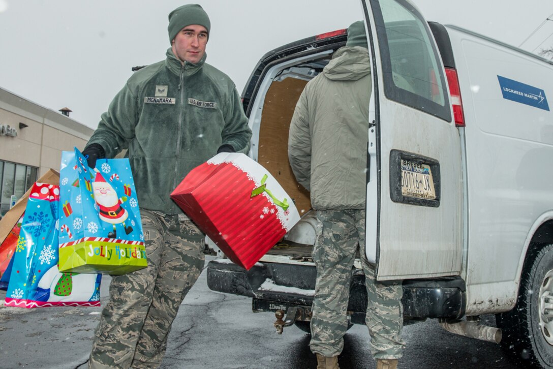 Senior Airman Andrew McNamara of The Eastern Air Defense Sector, helps carry gifts that were received at Shoppingtown Mall on 13 December 2013. The gifts will be distributed downtown at the Oncenter through American Red Cross on 23 December 2013. 