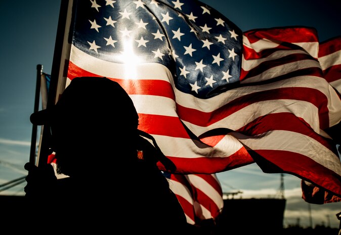 A South Carolina Patriot Guard member lines up along a Charleston, S.C., pier holding an American flag in honor of the United States Coast Guard national security cutter Gallatin (WHEC 721) and its 170-member crew’s return Dec. 11, 2013, after the ship’s final patrol. Gallatin’s crew seized more than 1,000 kilos of cocaine with a street value of $34 million. (U.S. Air Force photo/ Senior Airman Dennis Sloan)