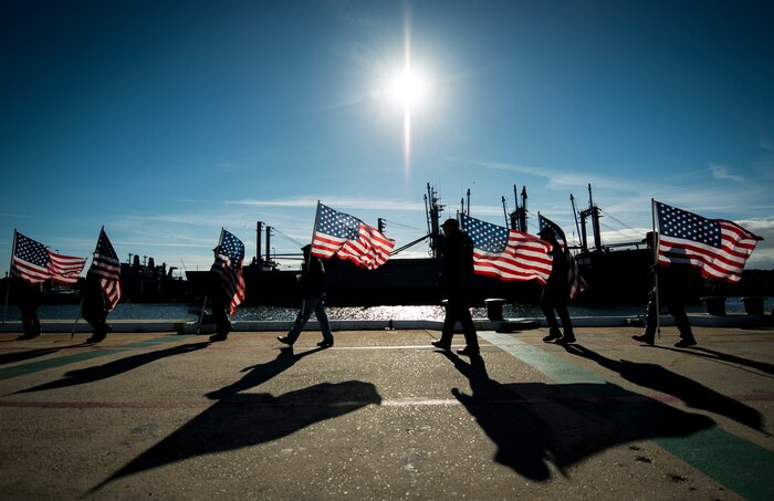 South Carolina Patriot Guard members line-up along a Charleston, S.C., pier holding American flags in honor of the United States Coast Guard national security cutter Gallatin (WHEC 721) and its 170 member crew’s return Dec. 11, 2013. During the ship’s final patrol, Gallatin’s crew seized more than 1,000 kilos of cocaine with a street value of $34 million. (U.S. Air Force photo/ Senior Airman Dennis Sloan)