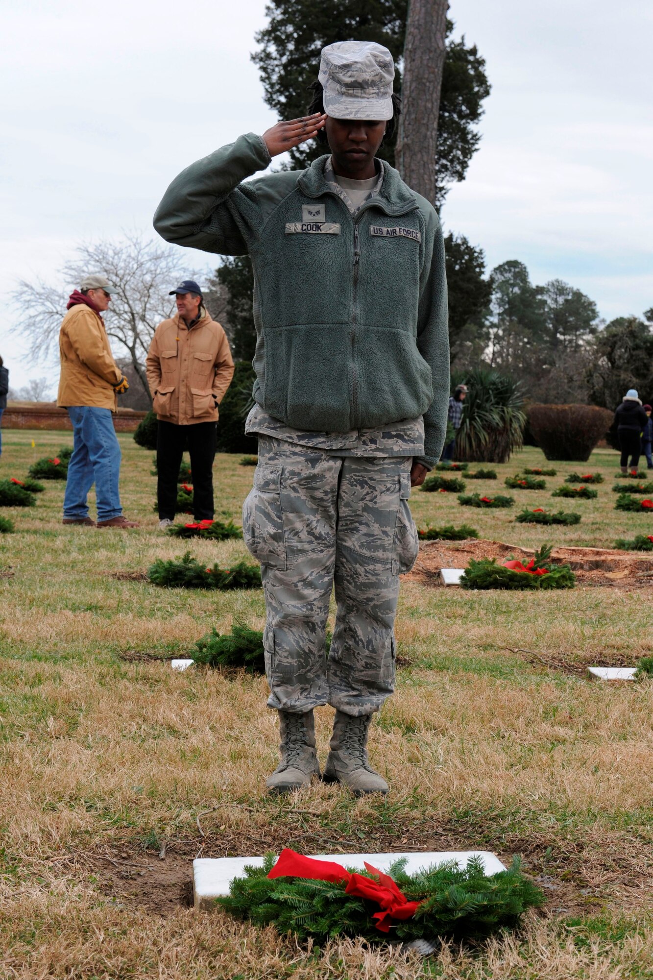 U.S. Air Force Senior Airman Charnelle, 497th Operations Support Squadron intelligence analyst, salutes a wreath placed at the grave of a fallen Service member at Yorktown National Cemetery in Yorktown, Va., Dec. 14, 2013. The wreaths were laid in honor of National Wreaths Across America Day, now in its 20th year. Charnelle hails from Atlanta. (U.S. Air Force photo by Staff Sgt. Ciara Wymbs/Released) (Last name withheld for security reasons)