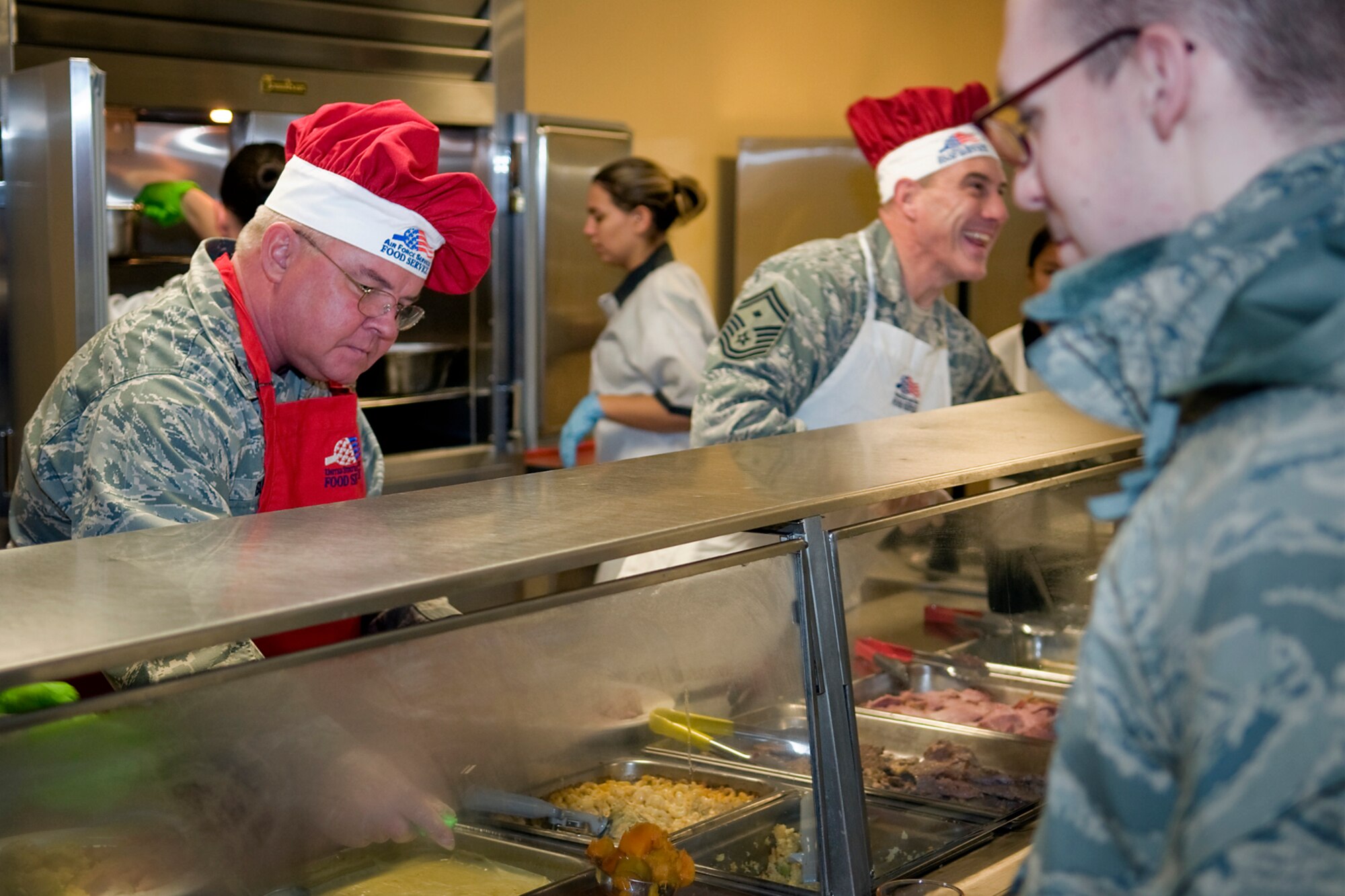 Col. Don Buckley, 434th Air Refueling Wing commander, and Senior Master Sgt. Matthew Zahradka, 434th Maintenance Squadron first sergeant, serve food to Airmen at Grissom Air Reserve Base, Ind., Dec. 7, 2013. Each year Grissom commanders, chief master sergeants and first sergeants don aprons and wield serving utensils to spread holiday cheer. (U.S. Air Force photo/Staff Sgt. Andrew McLaughlin)
