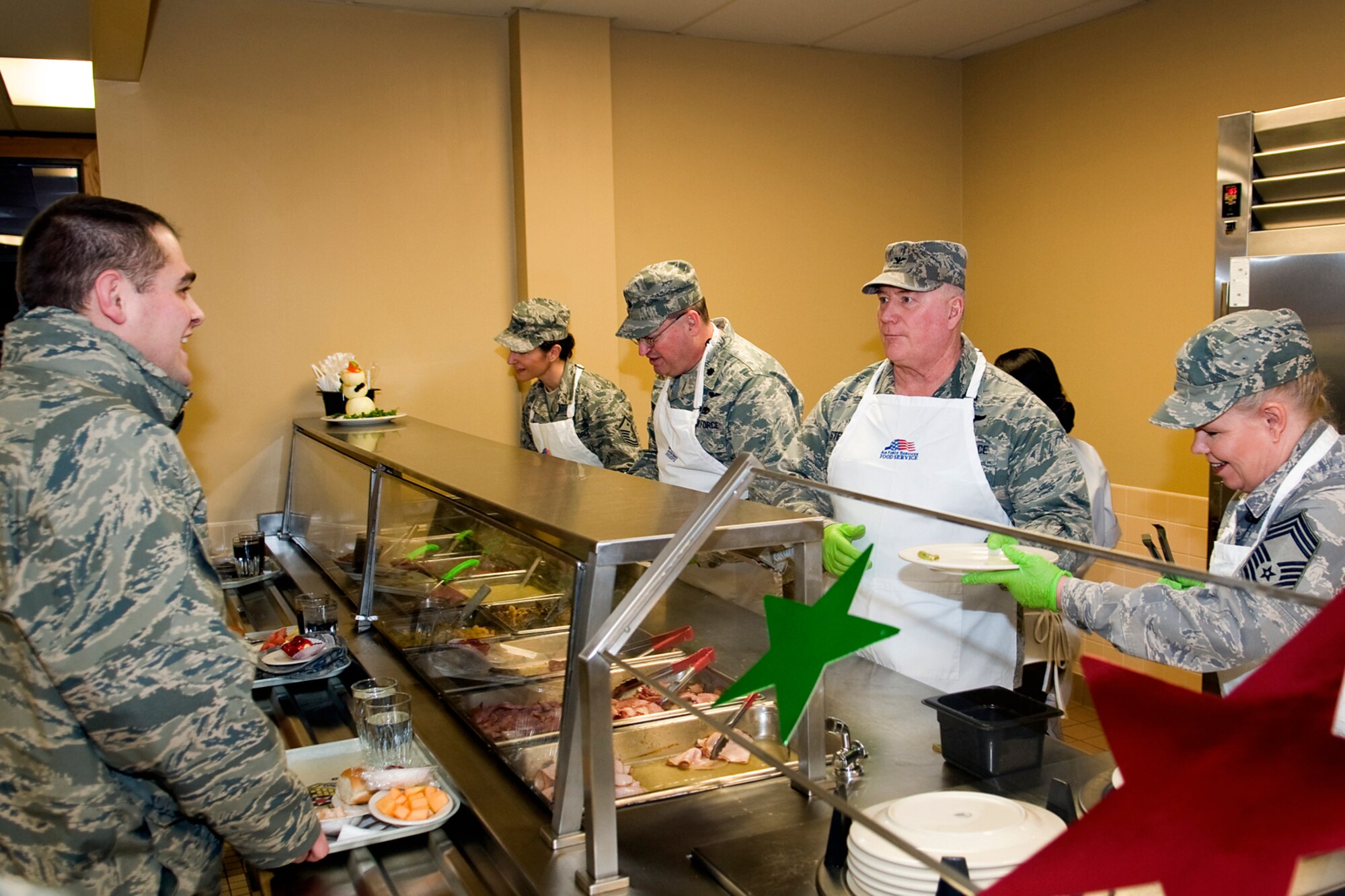 434th Air Refueling Wing leaders serve food to Airmen at Grissom Air Reserve Base, Ind., Dec. 7, 2013. Serving from left to right are Master Sgt. Wendi Conwell, 434th Aerospace Medicine Squadron first sergeant; Lt. Col. Bryan Runion, 434th Logistics Readiness Squadron commander; Col. William Stephens, 434th Mission Support Group commander; and Chief Master Sgt. Louise Dietzer-Hensley, 434th AMDS aerospace medical services manager. (U.S. Air Force photo/Staff Sgt. Andrew McLaughlin)
