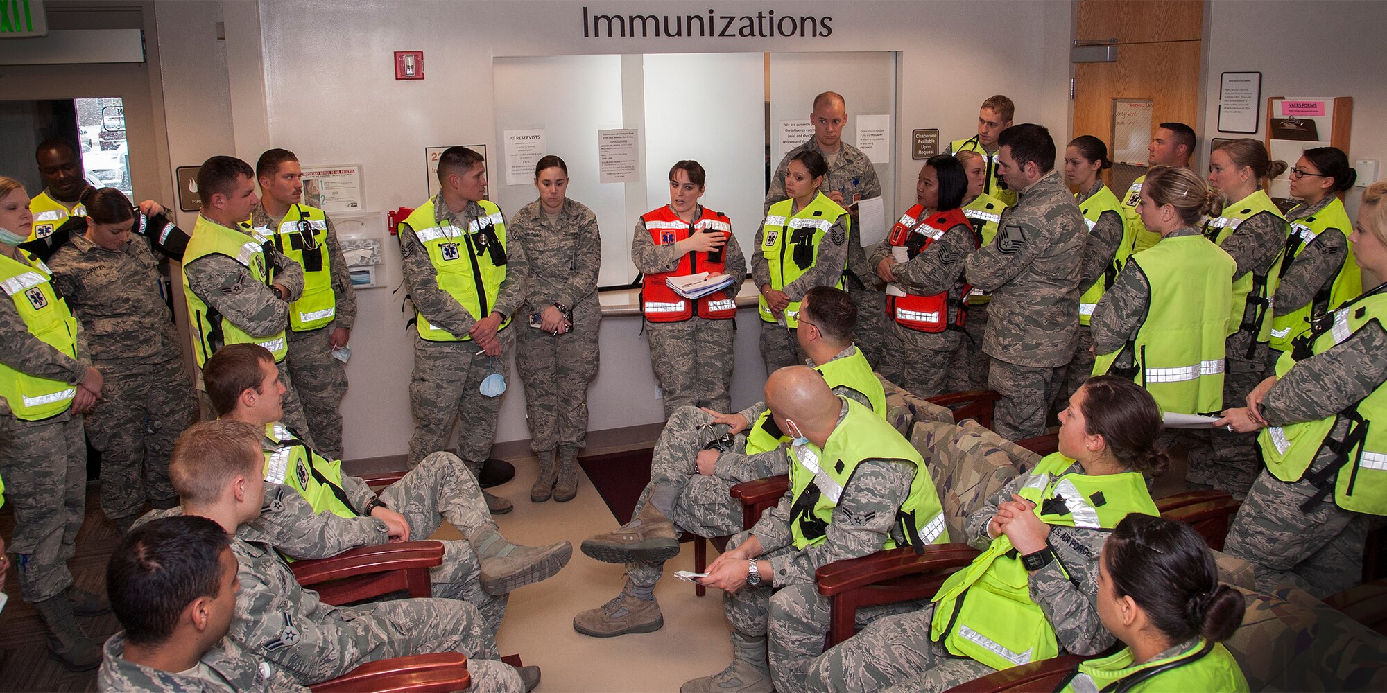 PETERSON AIR FORCE BASE, Colo. – Capt. Erin Brown, family nurse practitioner, 21st Medical Operations Squadron, (center red vest) discusses dosing information for patients who have been affected by a new strain of influenza during an exercise here Dec. 4. The colored vests are worn by medical personnel for easy identification. The 21st MDG set up vaccine distribution points at Peterson, Schriever Air Force Base and Cheyenne Mountain Air Force Station, and countered the threat by prioritizing the administration of limited preventive medicine. (U.S. Air Force photo/Craig Denton)