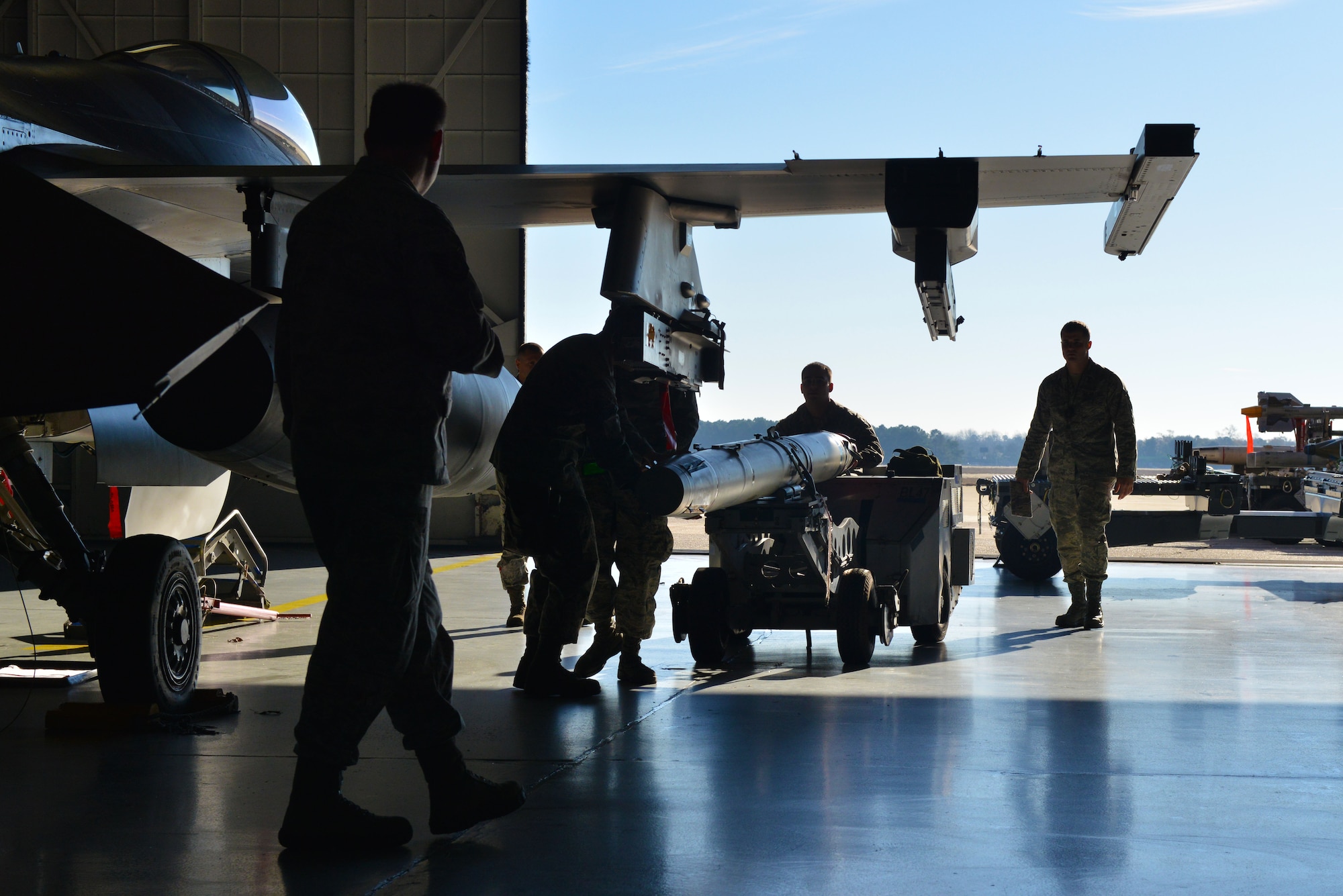 U.S. Air Force Airmen from the 20th Aircraft Maintenance Squadron, Shooter Aircraft Maintenance Unit weapons load crew team prepare to attach a missile on an F-16 Fighting Falcon, Shaw Air Force Base, S.C., Dec. 13, 2013. The crew was being evaluated throughout the process to ensure they were following proper loading procedure. (U.S. Air Force photo by Airman 1st Class Jensen Stidham/Released)