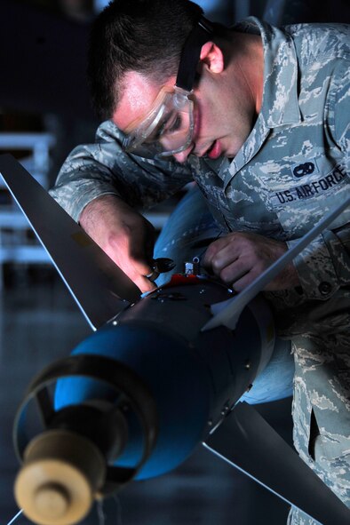 U.S. Air Force Airman 1st Class Russell Voyles, 20th Aircraft Maintenance Squadron, Shooter Aircraft Maintenance Unit weapons load crew member, prepares a missile on an F-16 Fighting Falcon, Shaw Air Force Base, S.C., Dec. 13, 2013. Voyles along with his crew worked together to load munitions during the fourth quarter load crew competition. (U.S. Air Force photo by Airman 1st Class Jensen Stidham/Released) 