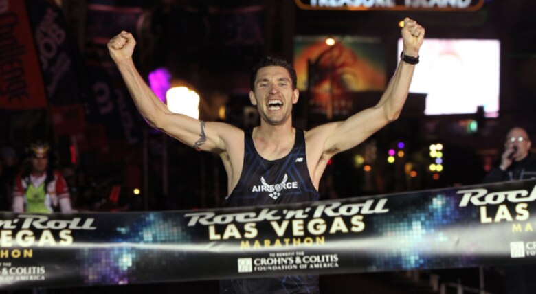 LAS VEGAS, Nev. – Capt. Jason Brosseau, 76th Space Control Squadron crew commander raises his arms in victory as he crosses the finish line, clinching first place at the Rock ‘n’ Roll Marathon Series in Las Vegas. Brosseau credited his success to his six months of desert training while deployed to Al Udeid Air Base, Qatar. The hot and dry weather in Qatar allowed Brosseau to acclimate and condition himself for the full marathon in Las Vegas. (Courtesy photo)