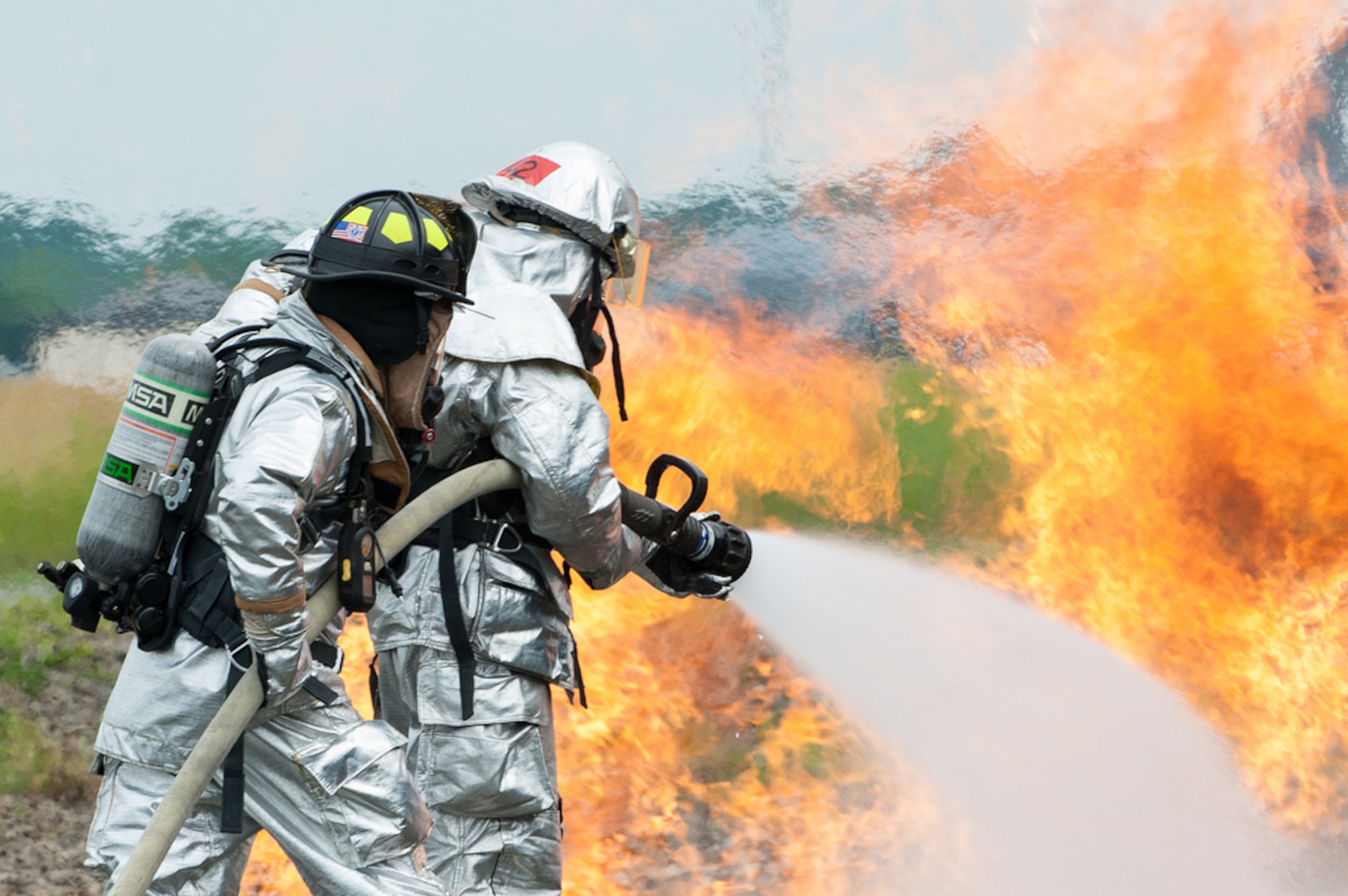Firefighters from the 87th Civil Engineer Squadron extinguish flames from a trainer aircraft during a live fire burn exercise June 18, 2013, at Joint Base McGuire-Dix-Lakehurst, N.J. The CES firemen go thru the training two times a year to be recertified.(U.S. Air Force photo by Russ Meseroll/Released)