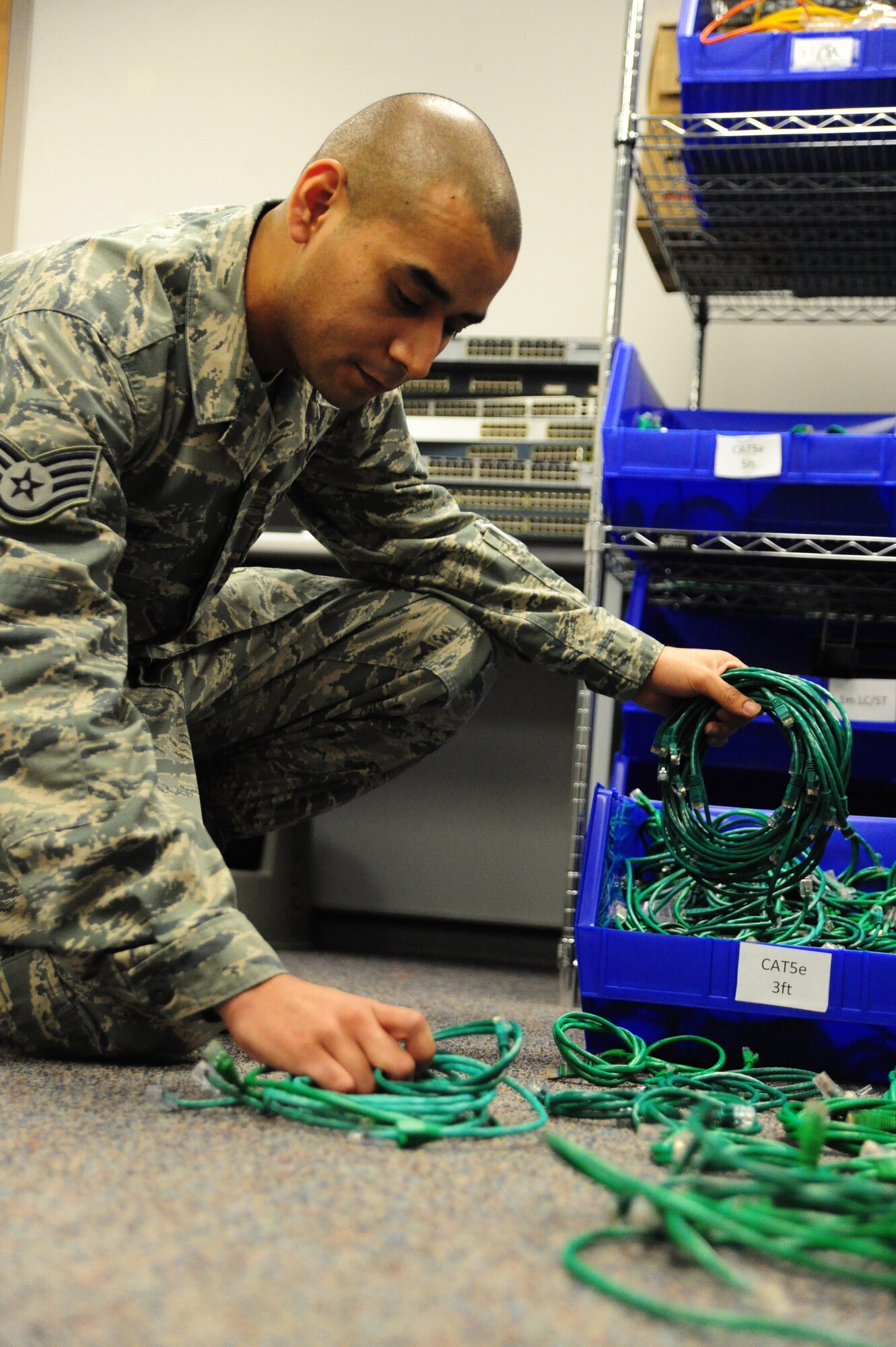 Staff Sgt. Gabriel Lopez, 509th Communications Squadron network technician, accesses cables to activate ports for a customer at Whiteman Air Force Base, Mo., Dec. 5, 2013. Network technicians are responsible for maintaining all types of networks on base and allowing Airmen to access the Global Information Grid. (U.S. Air Force photo by Staff Sgt. Nick Wilson/Released)