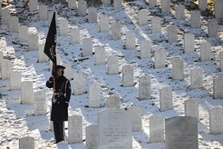 A U.S. Air Force Honor guardsman holds the Prisoner of War Flag during a funeral honoring Col. Francis J. McGouldrick Dec. 13, 2013, at Arlington National Cemetery, Va. McGouldrick was laid to rest after being mission in action for 45 years. McGouldrick’s remains were found in a remote jungle in Laos. (U.S. Air Force photo/Airman 1st Class Nesha Humes)
