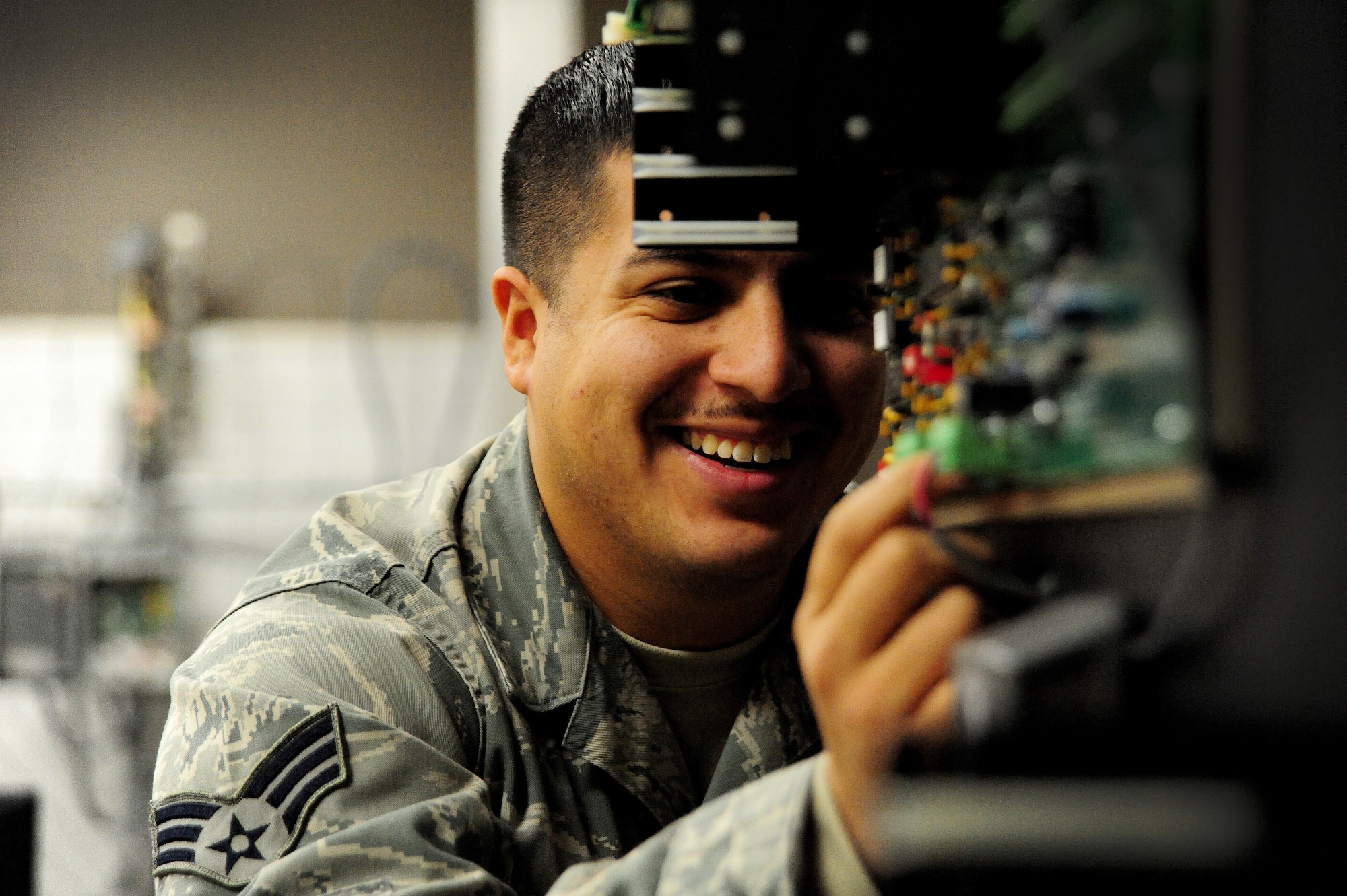 Senior Airman Luis Rojas, 509th Communications Squadron intrusion detection systems technician, checks connections on the motherboard of an alarm system at Whiteman Air Force Base, Mo., Dec. 5, 2013. This alarm recognizes motion and vibrations and sends alert messages to security forces so they can respond. (U.S. Air Force photo by Staff Sgt. Nick Wilson/Released)