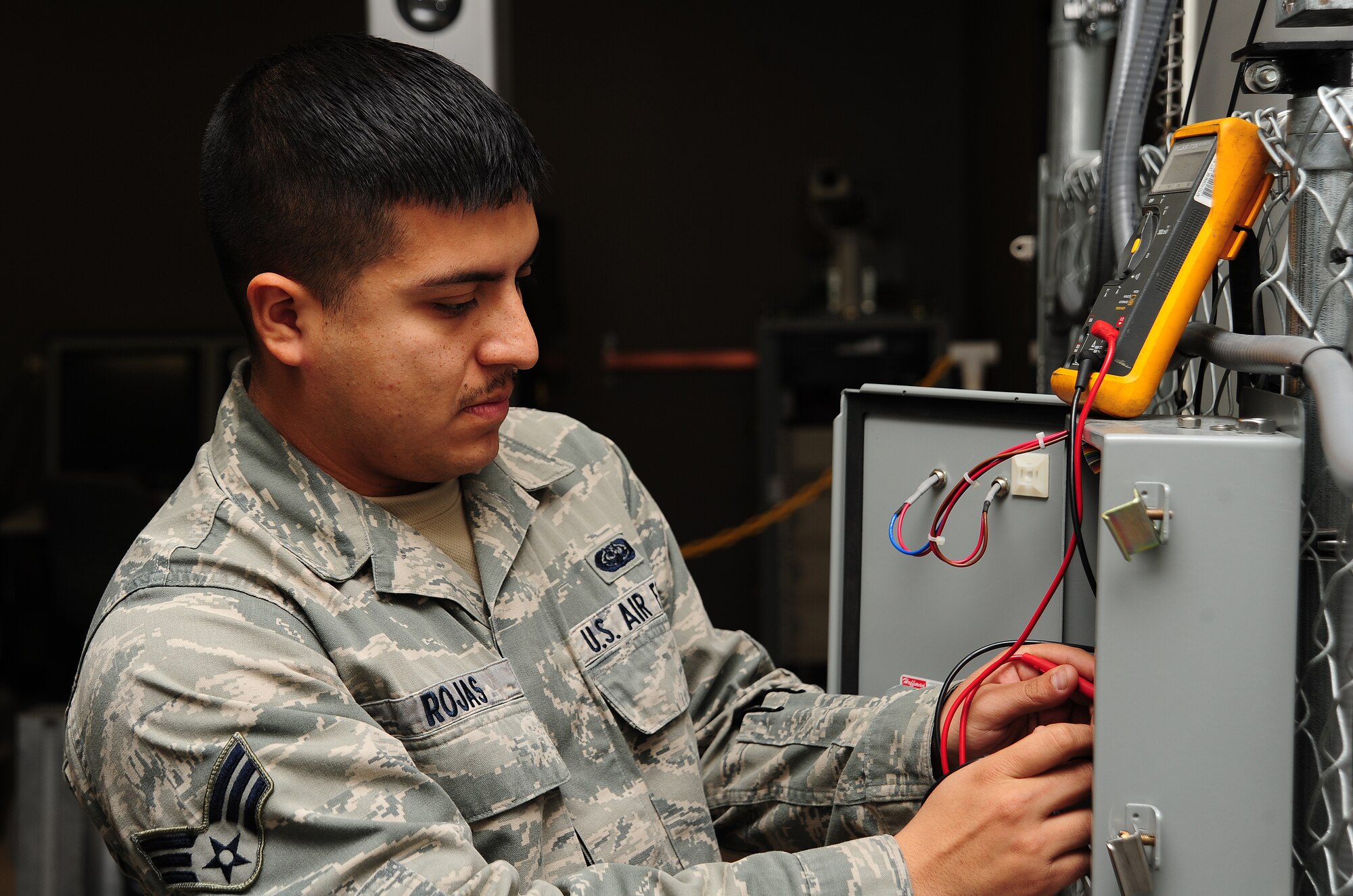 Senior Airman Luis Rojas, 509th Communications Squadron intrusion detection systems technician, checks electrical resistance with a multimeter to ensure an alarm is secure at Whiteman Air Force Base, Mo., Dec. 5, 2013. If the electrical current on the alarm is not at the correct measurement, then the device will not function properly. (U.S. Air Force photo by Staff Sgt. Nick Wilson/Released)