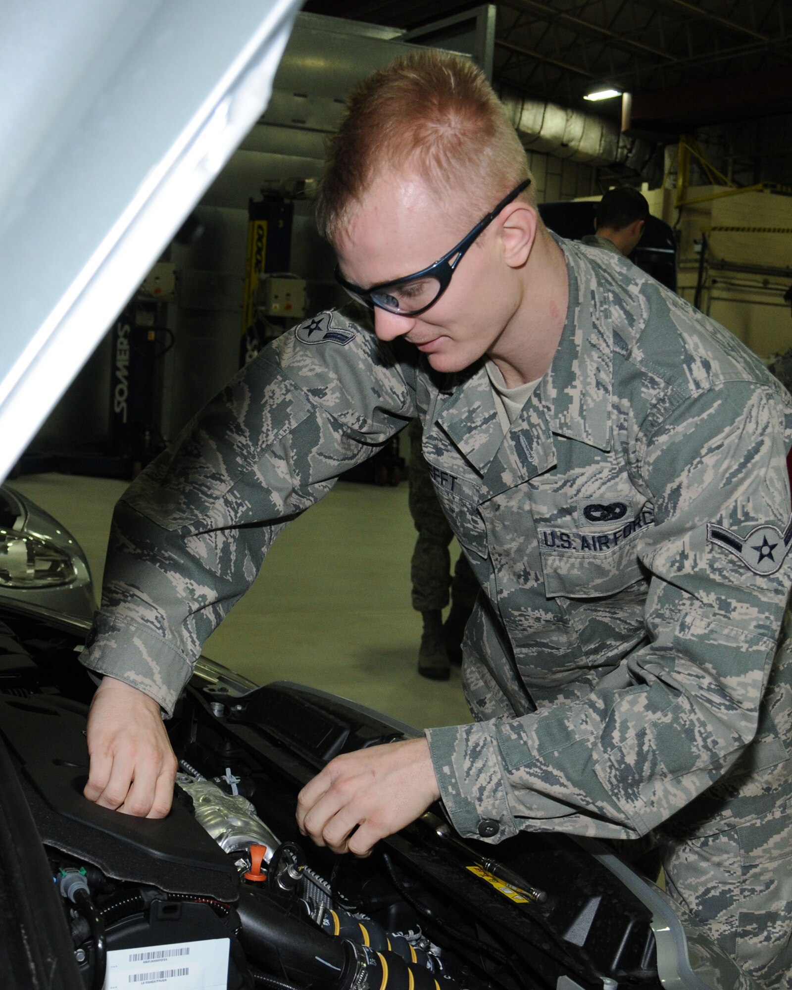 U.S. Air Force Airman 1st Class Wesley Tefft, 100th Logistics Readiness Squadron vehicle maintainer from Scottsdale, Ariz., inspects the engine of a newly assigned low-carbon, fuel-efficient diesel sedan Dec. 6, 2013, on RAF Mildenhall, England. The 100th LRS replaced 19 vehicles with a newer more environmentally friendly fleet. To further reduce the squadron’s carbon footprint, during the monthly vehicle inspections, the vehicle control officers check the tire pressure to ensure the tires are within the correct limits. This ensures fuel consumption is kept to a minimum due to proper tire pressure. (Editor’s note : At the time this photo was taken, Tefft was the rank of Airman. He has since been promoted). (U.S. Air Force photo by Gina Randall/Released)